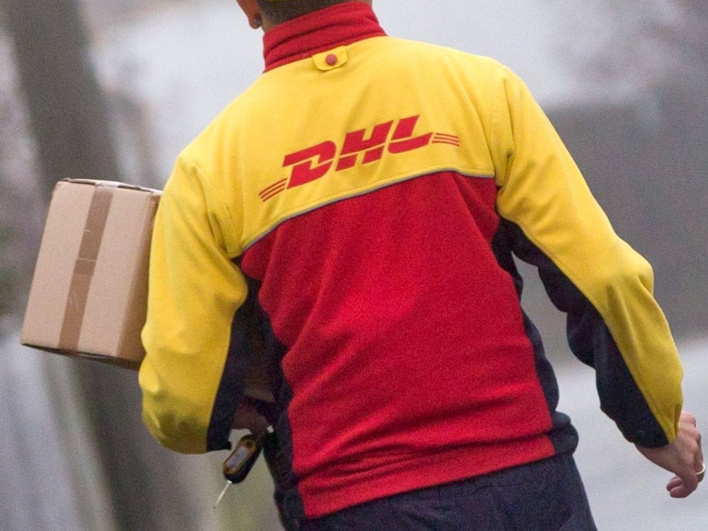 Ein DHL-Paketzusteller liefert in seinem Zustellbezirk Sendungen aus. Die Aufnahme stammt vom 9. Dezember 2014.
