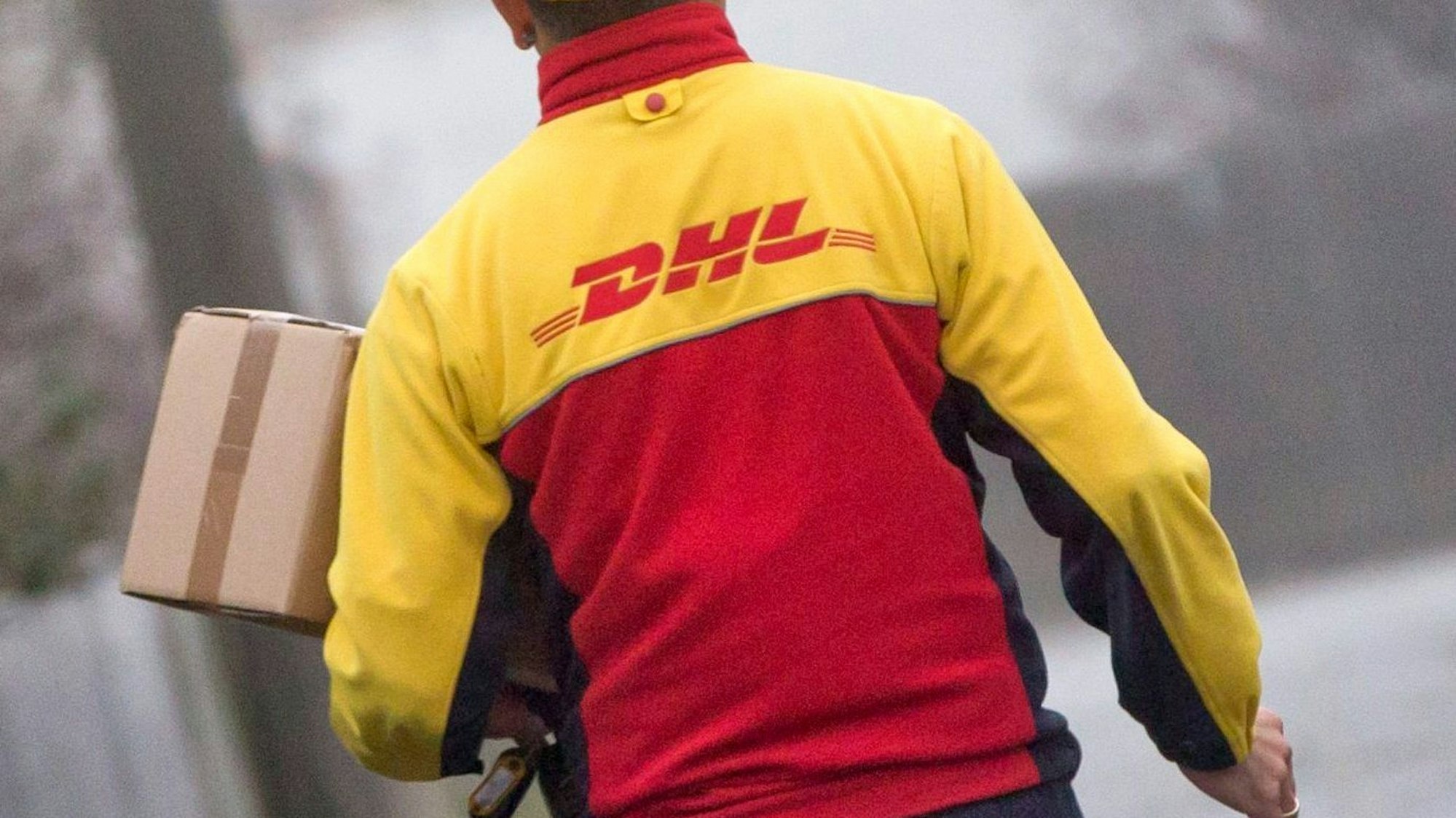 Ein DHL-Paketzusteller liefert in seinem Zustellbezirk Sendungen aus. Die Aufnahme stammt vom 9. Dezember 2014.