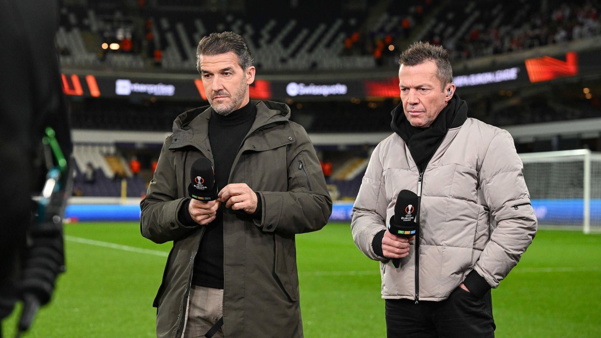 Die RTL-Experten Lothar Matthäus und Karl-Heinz Riedle (l.) halten bei einer TV-Übertragung ein Mikrofon in der Hand.