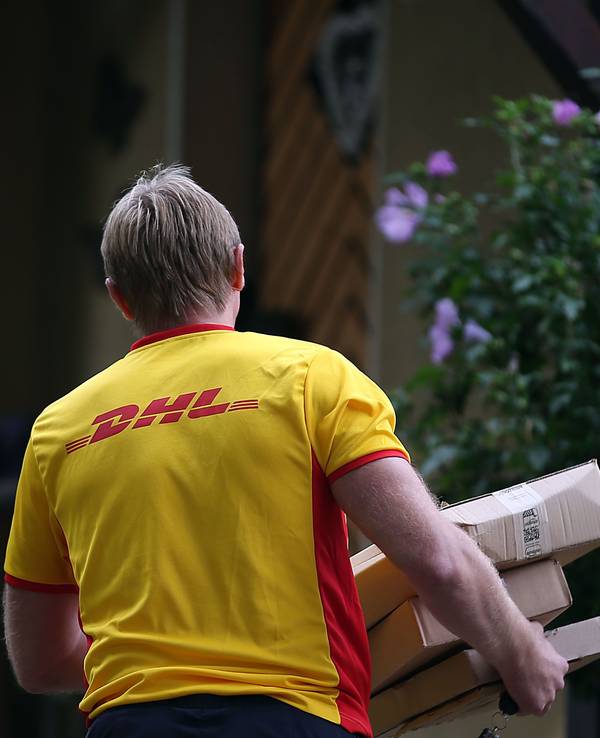 Ein Paketzusteller von DHL liefert Pakete aus.