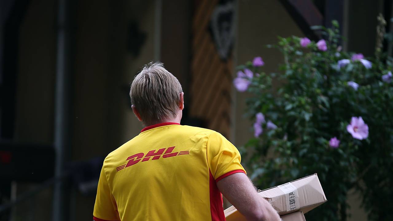 Ein Paketzusteller von DHL liefert Pakete aus.