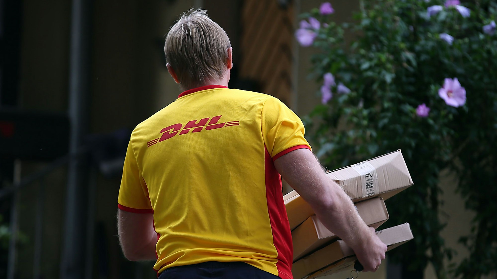 Ein Paketzusteller von DHL liefert Pakete aus.