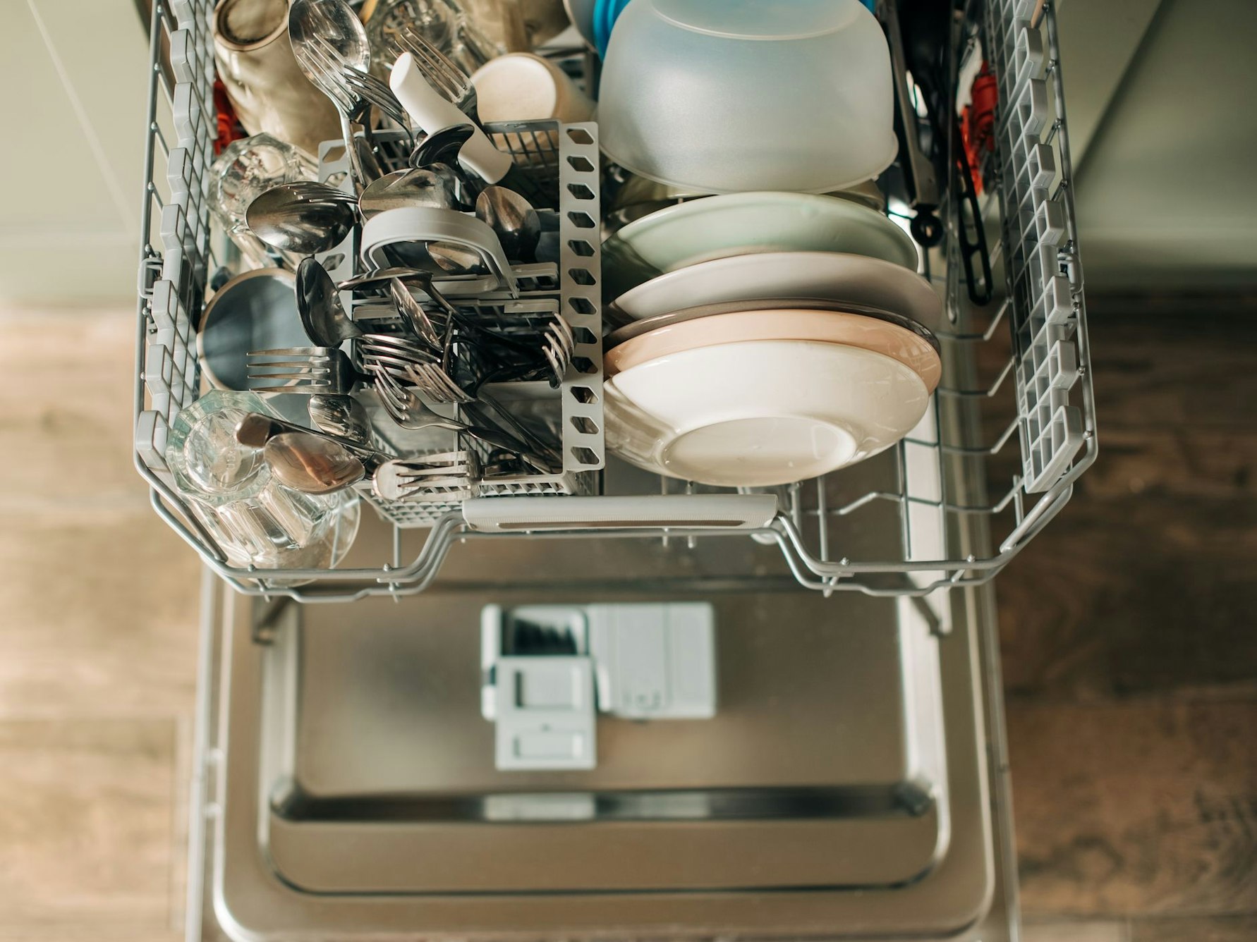 Auf dem Foto sieht man einen offenen Geschirrspüler mit sauberem Geschirr.
