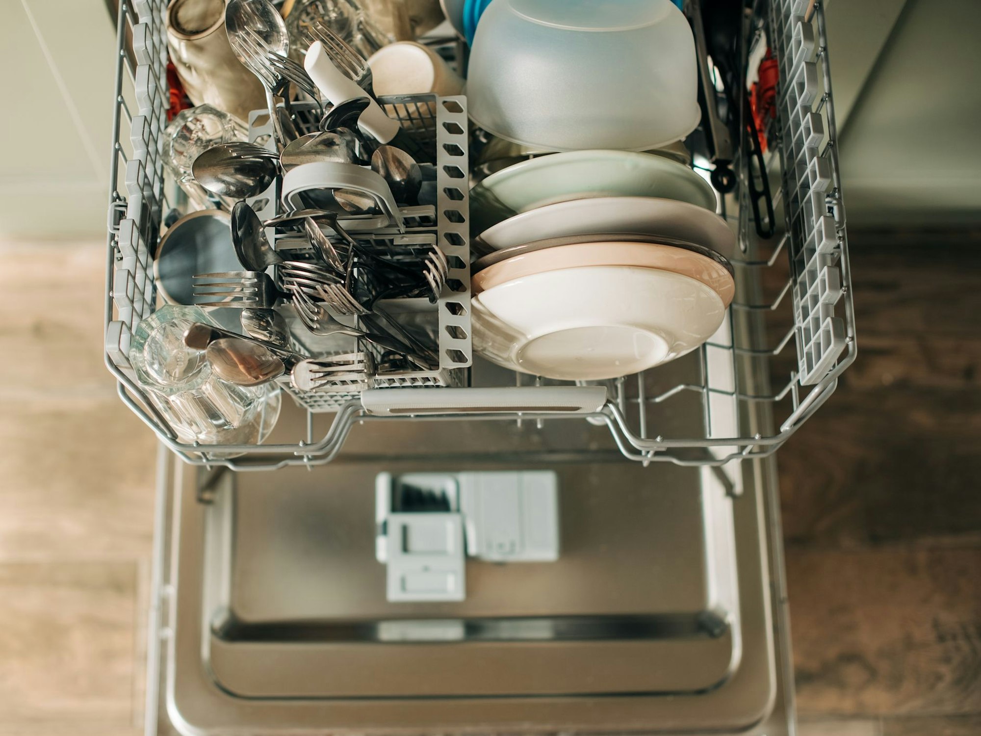 Auf dem Foto sieht man einen offenen Geschirrspüler mit sauberem Geschirr.