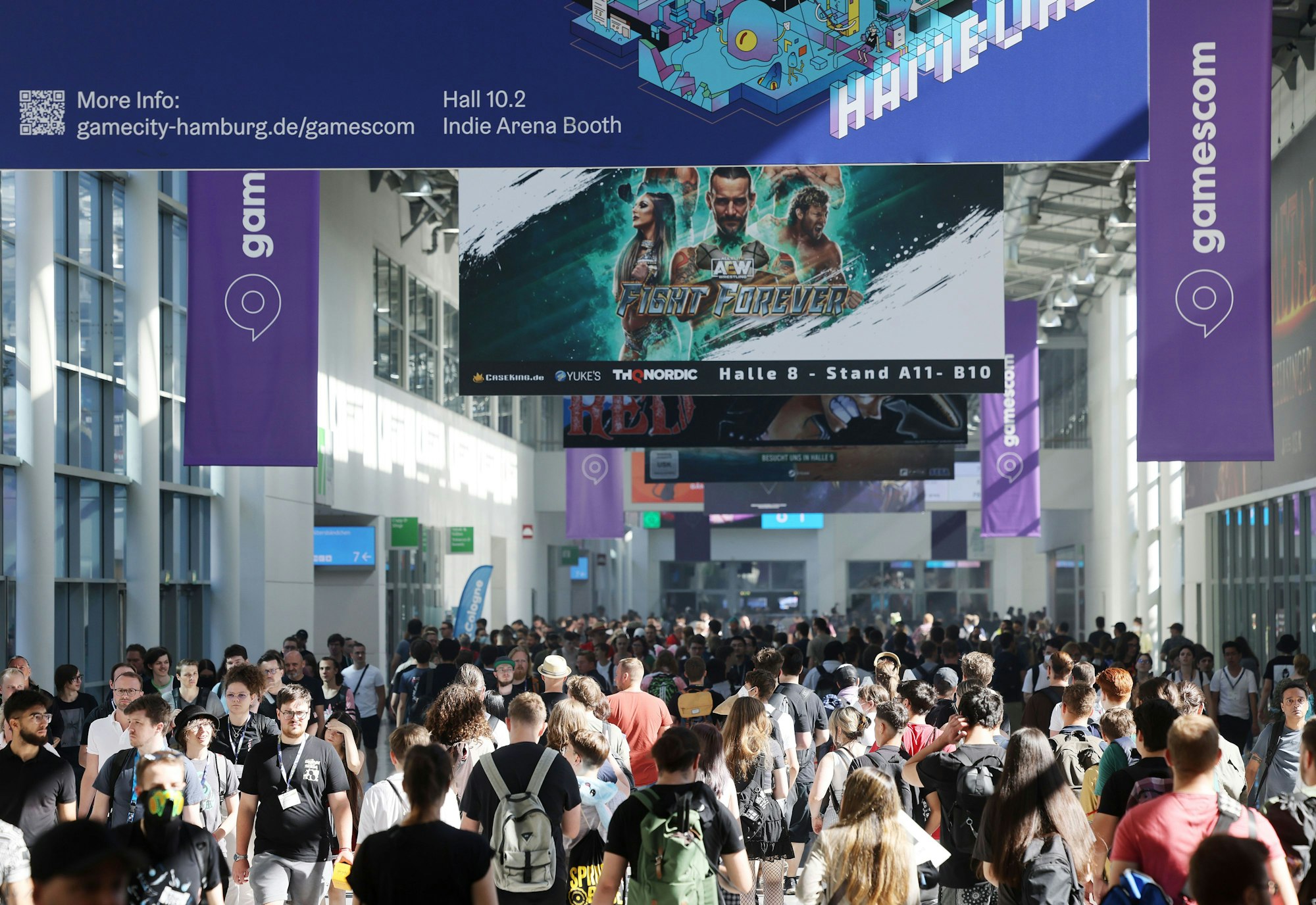 Messebesucherinnen und Besucher gehen über das Messegelände der Spielemesse Gamescom.