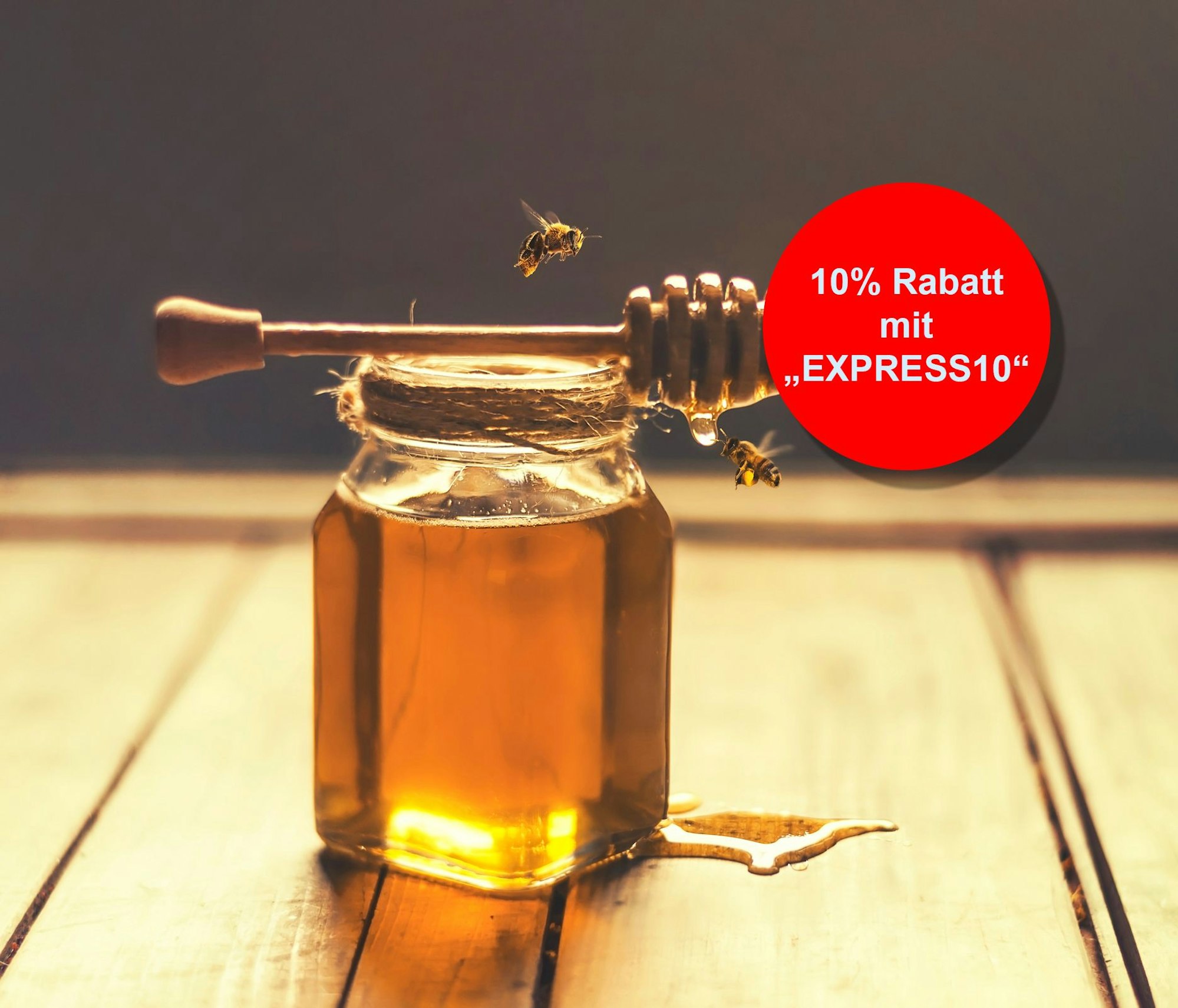 Indoor shot of a jar of honey with honey dripping from a honey dripper and flying bees