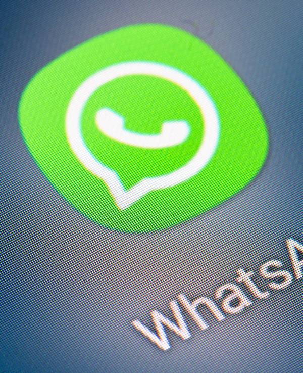 Auf dem Bildschirm eines Smartphones sieht man das Icon der App WhatsApp.