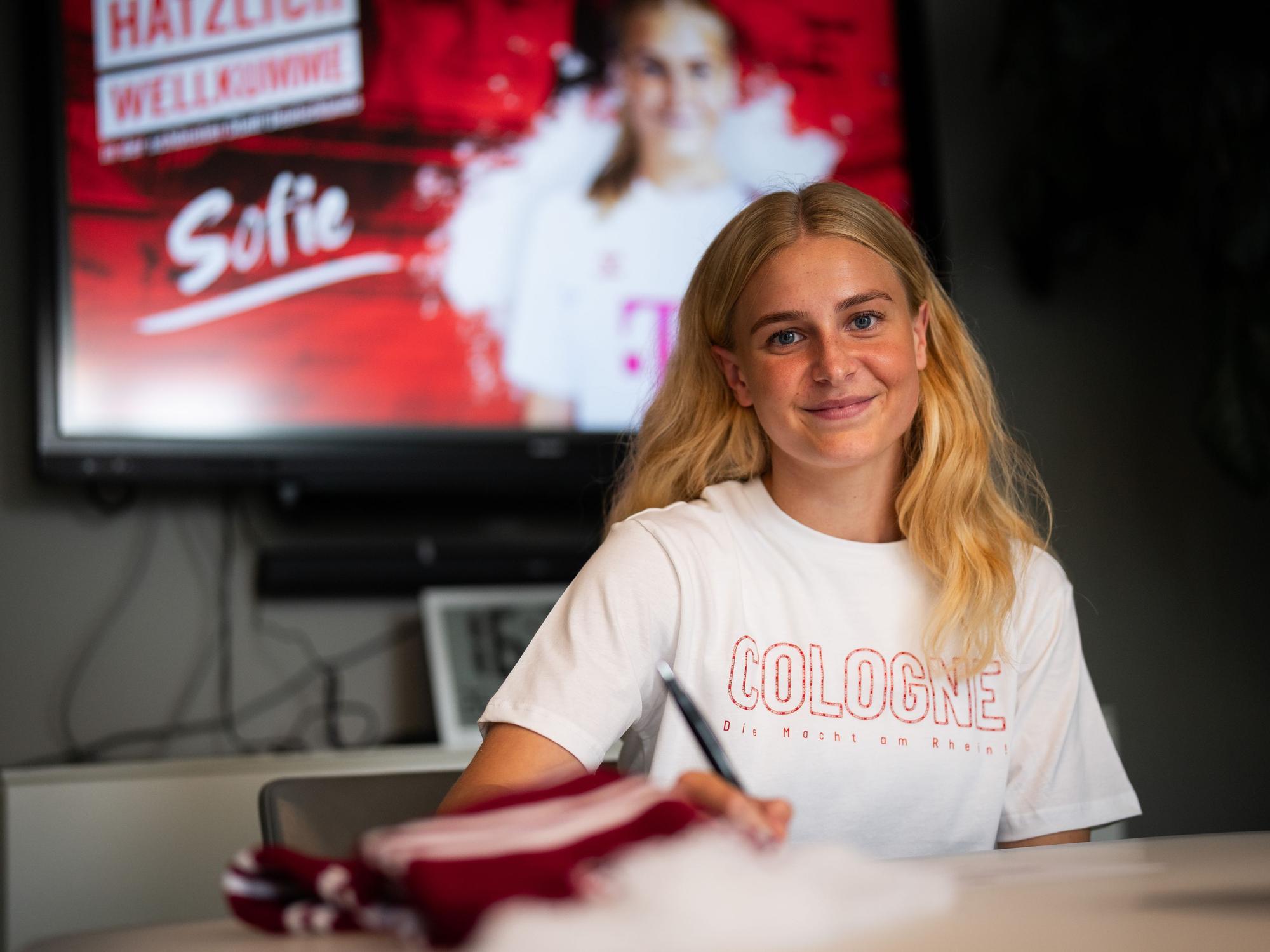 Sofie Vendelbo lächelt bei ihrer Vertragsunterschrift in die Kamera.