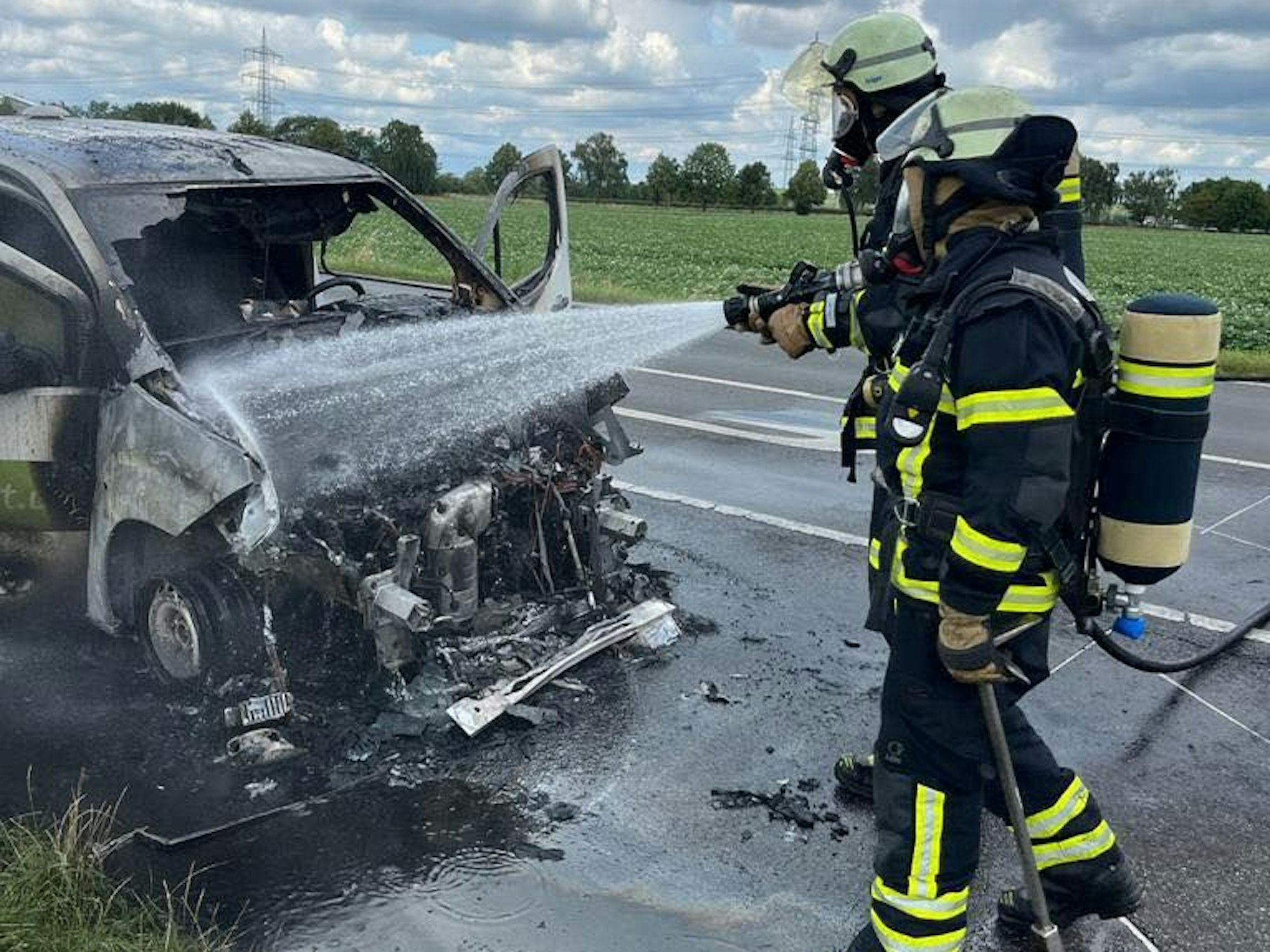 Einsatzkräfte der Hürther Feuerwehr löschen einen in Brand geratenen Kastenwagen.