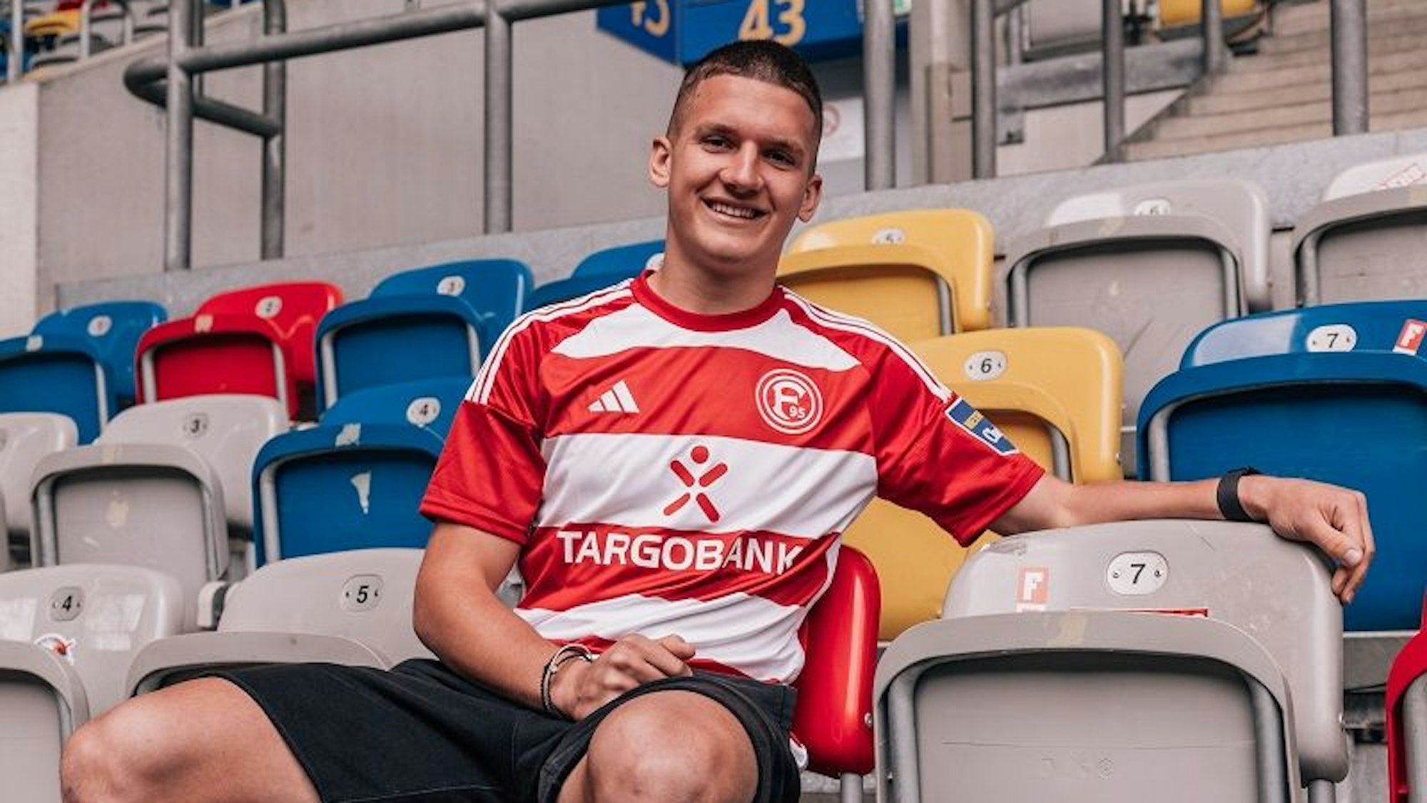 Christos Tzolis posiert im Fortuna-Düsseldorf-Trikot in der Merkur-Spiel-Arena.