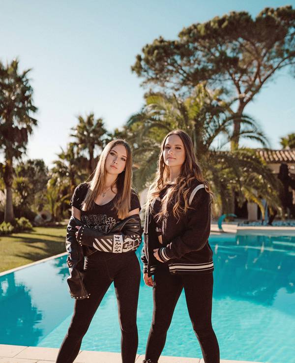 Davina Shakira Geiss (18, r) und Shania Tyra Geiss (17) stehen vor einem Pool.