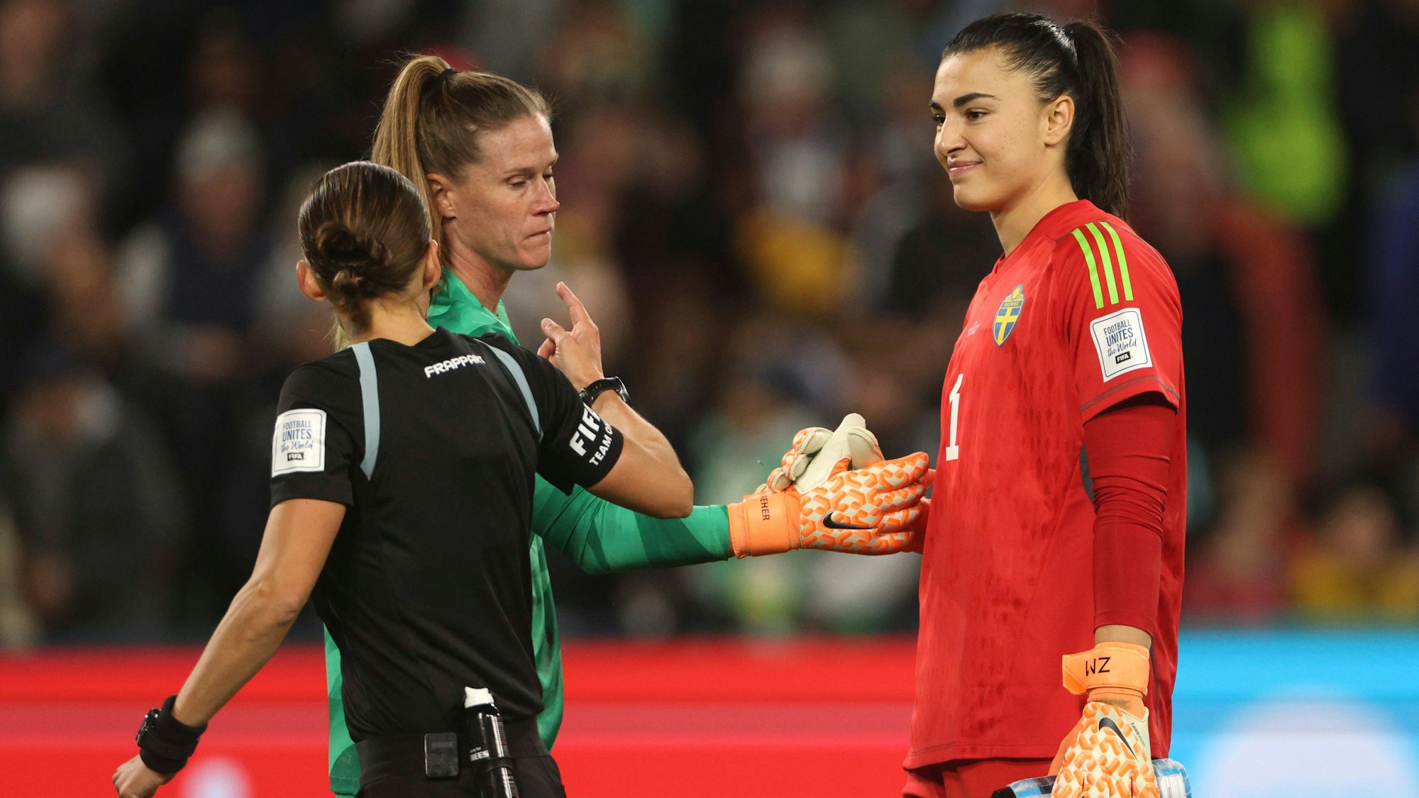 Stéphanie Frappart spricht vor dem Elfmeterschießen zwischen Schweden und den USA bei der Frauen-WM mit den beiden Torhüterinnen.