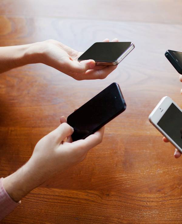 Vier Hände halten je ein Smartphone.