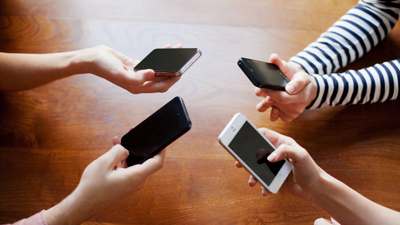 Vier Hände halten je ein Smartphone.