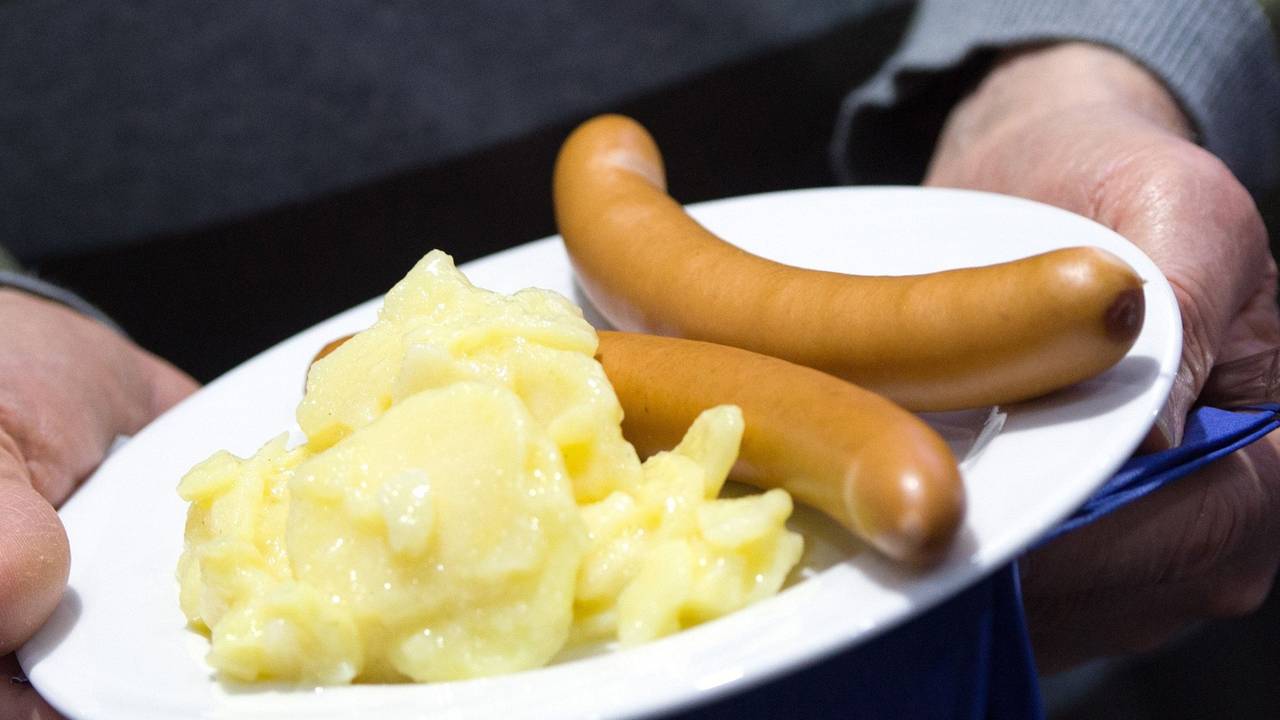 Würstchen mit Kartoffelsalat liegen auf einem Teller.