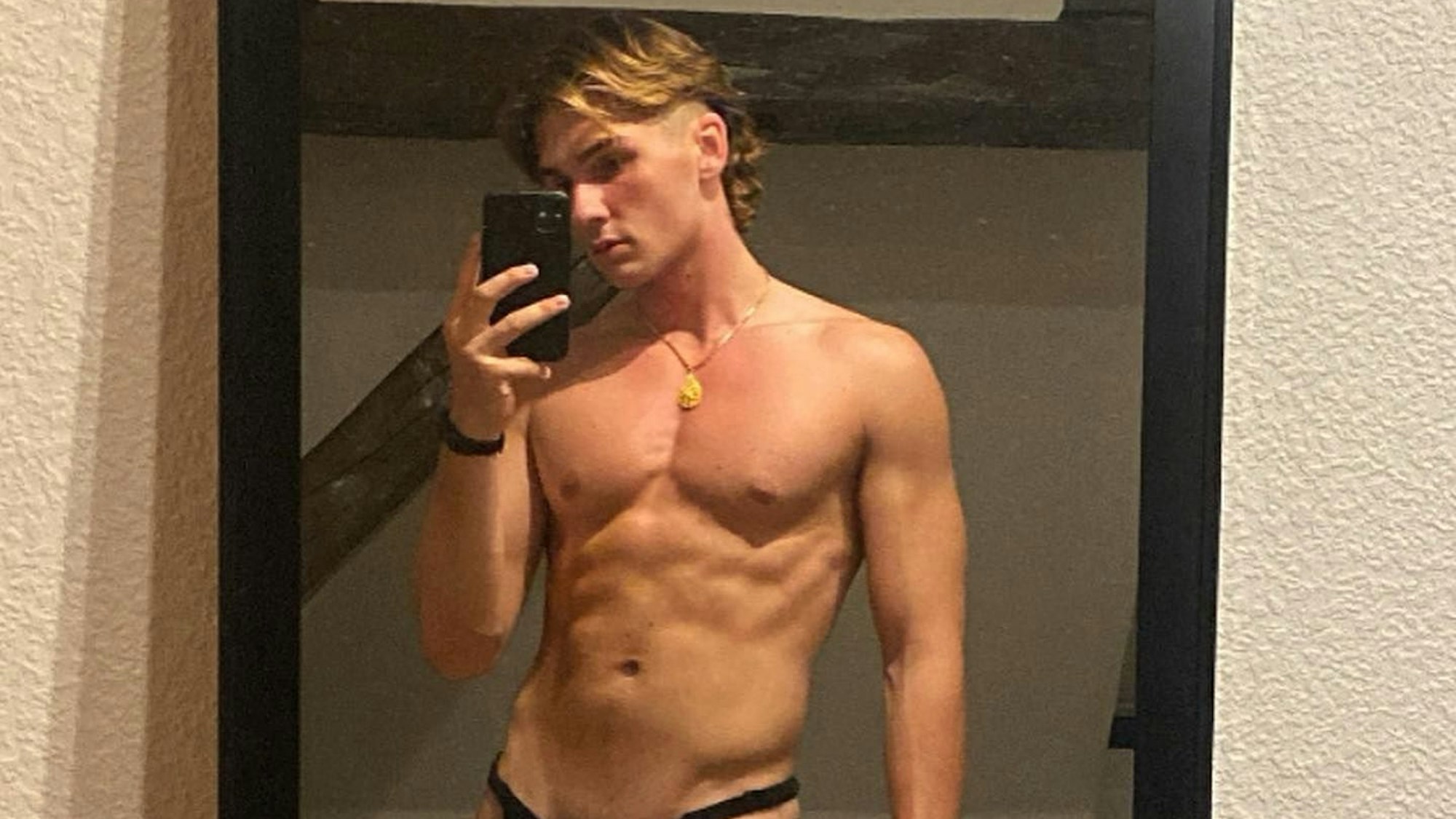 Leon Hirsack steht vor einem Ganzkörperspiegel und fotografiert sich.