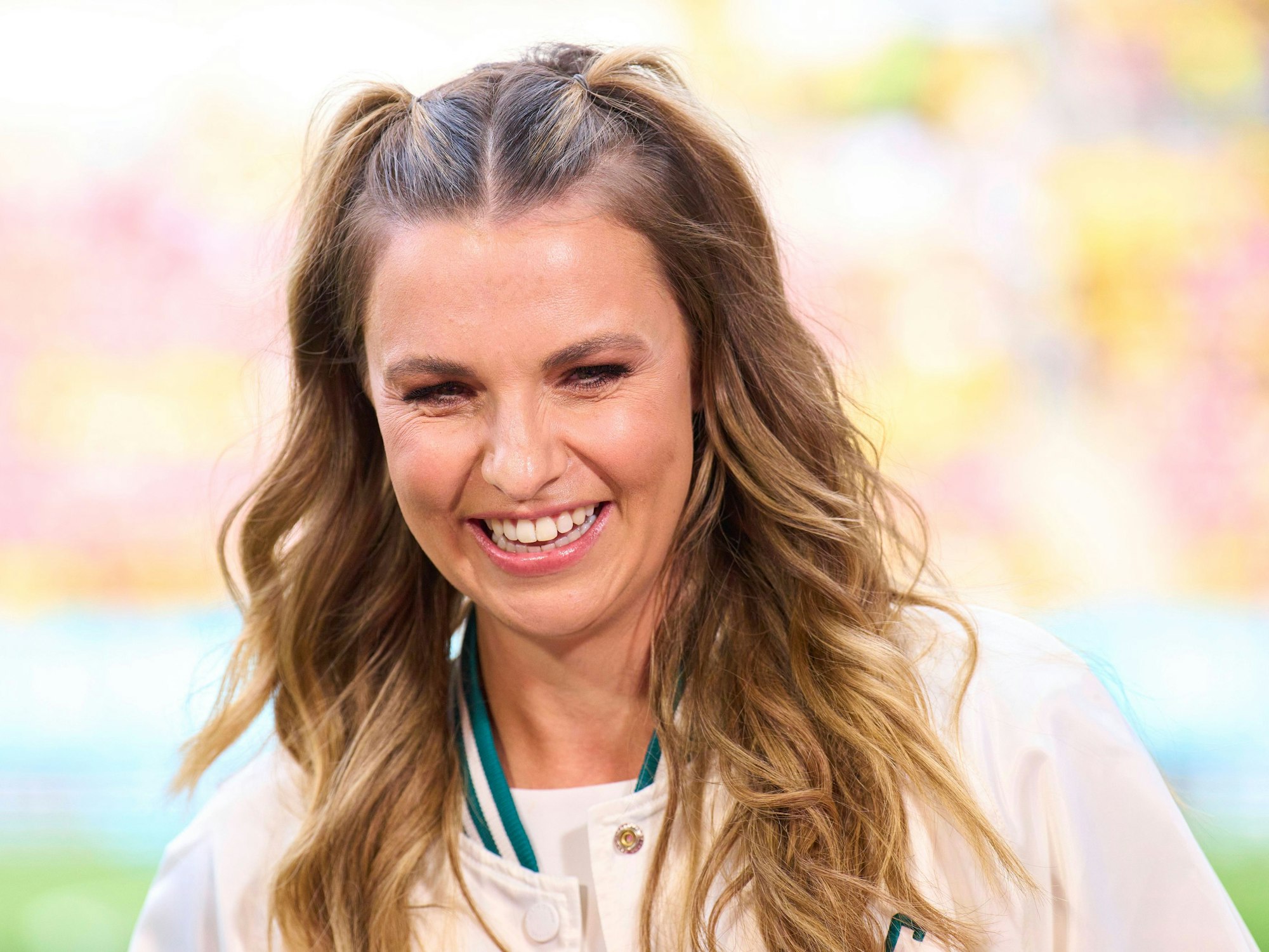 Laura Wontorra lacht am Spielfeldrand.