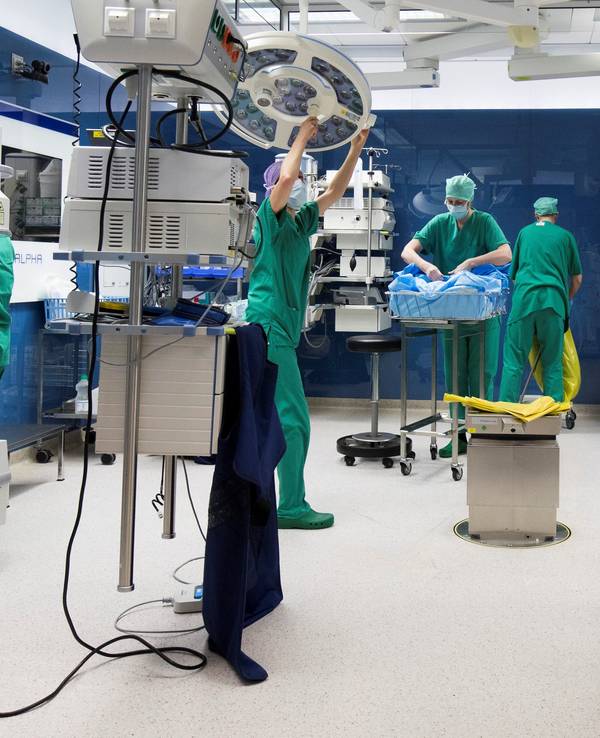 Unser Symbolbild zeigt OP-Personal und ein OP-Reinigungsteam. Sie arbeiten nach einer Operation in einem Operationssaal in einer Klinik im Jahr 2017.