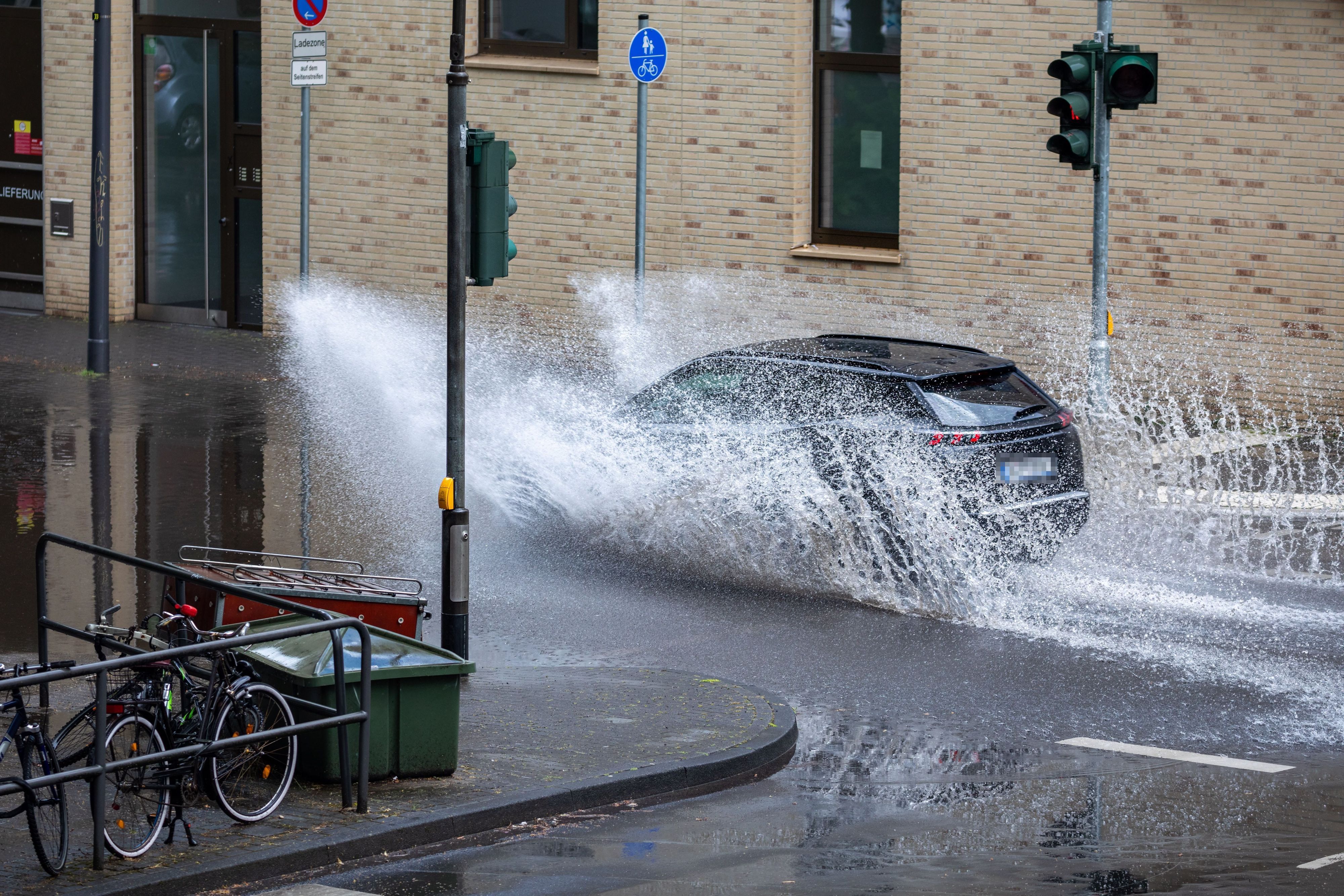 Ein Auto fährt durch eine Pfütze am Sülzgürtel.
