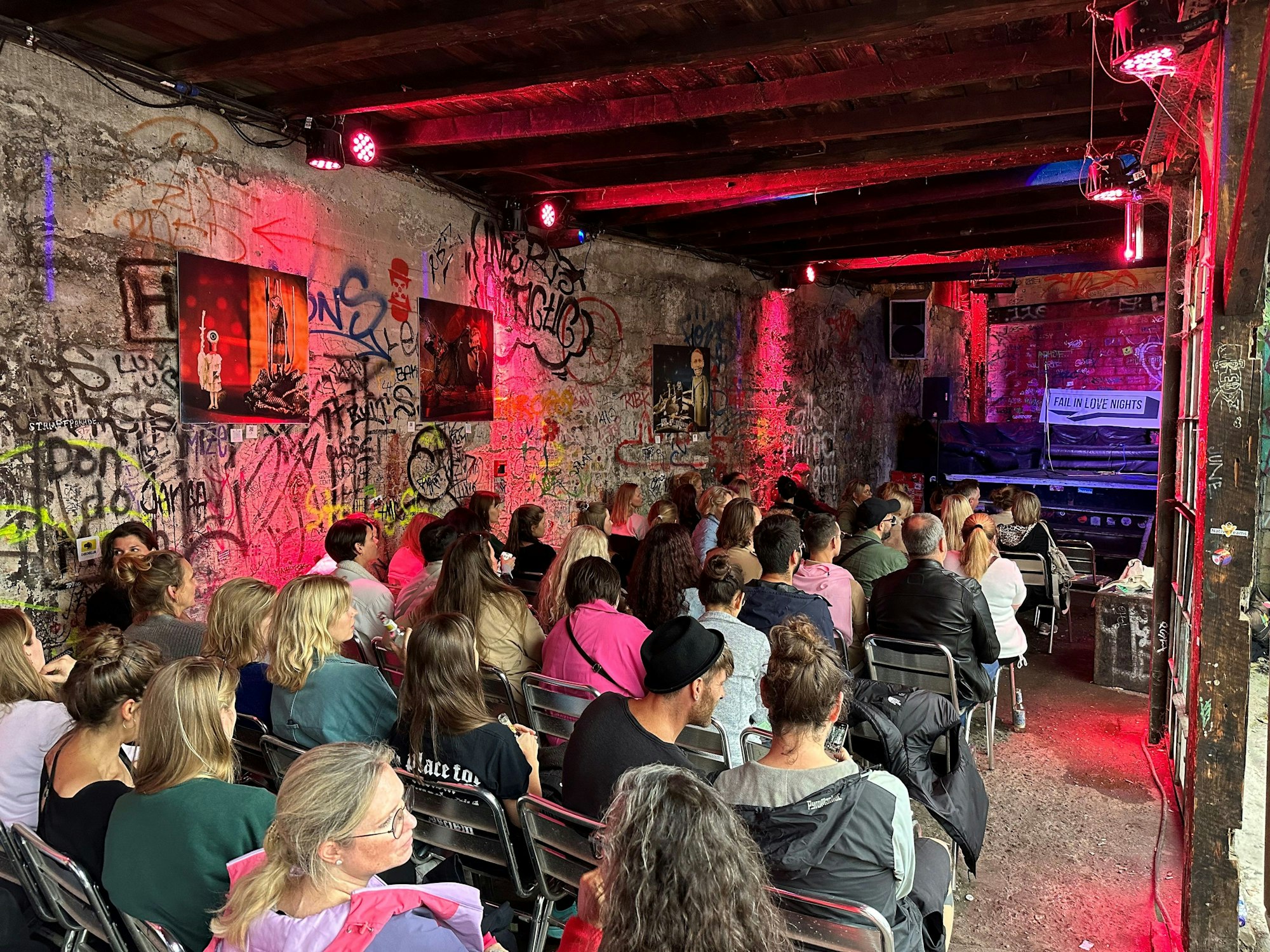 Das Publikum sitzt im Wintergarten des Odonien und schaut Richtung Bühne.