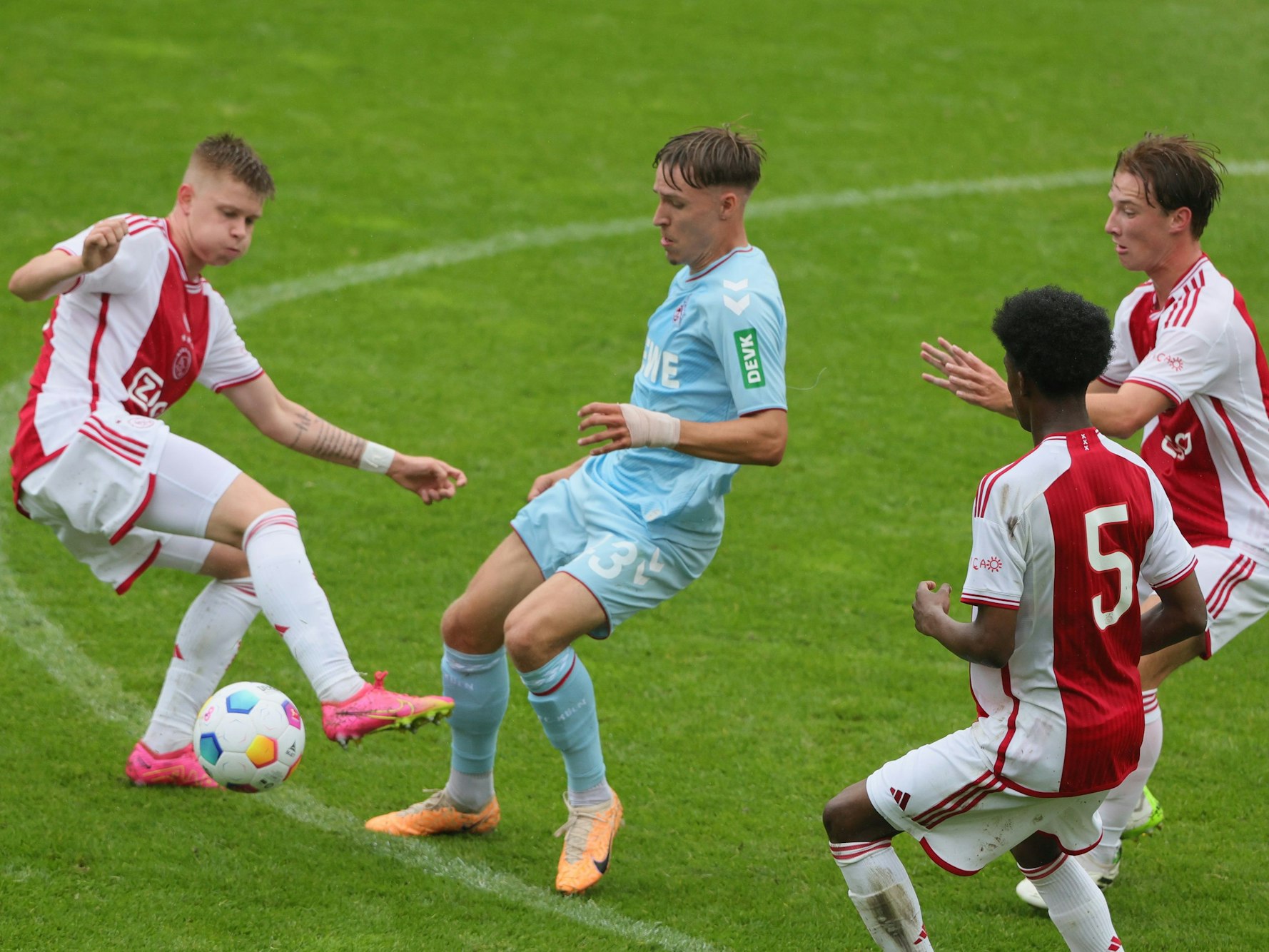 Maximilian Schmid vom 1. FC Köln im Duell mit drei Gegenspieler von Ajax Amsterdam.