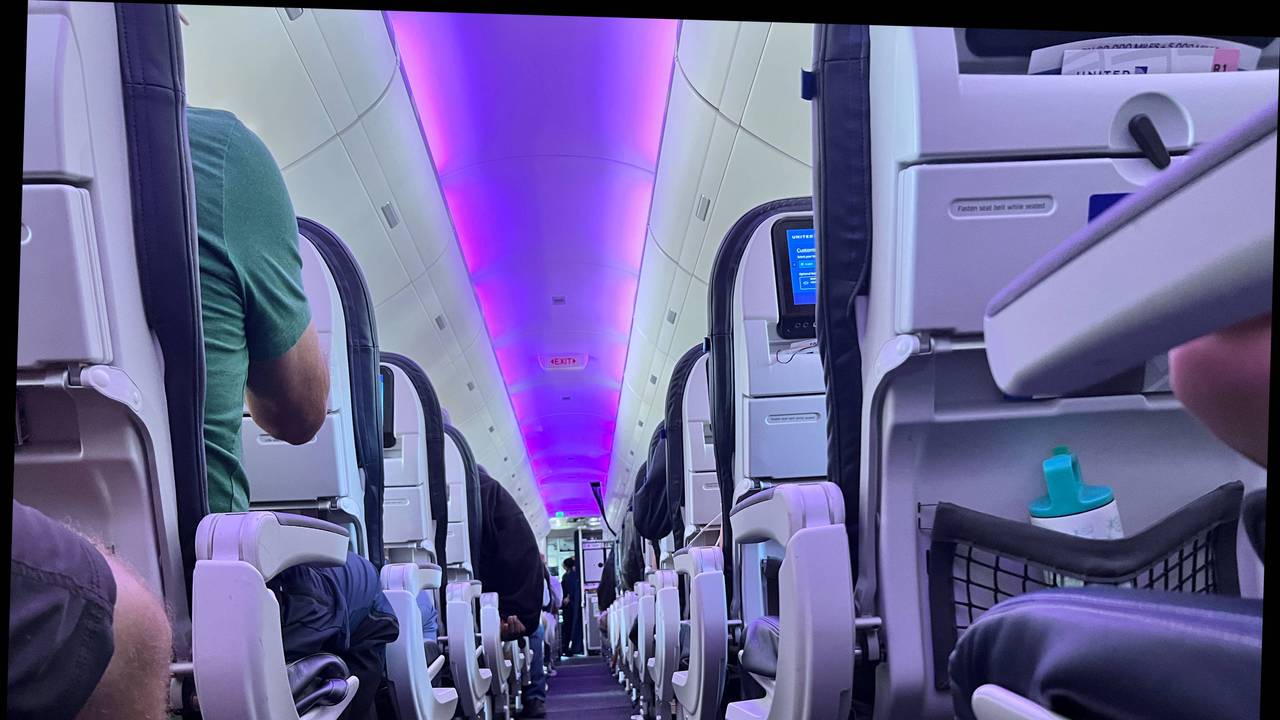 Menschen sitzen im Innenraum einer Maschine der Fluggesellschaft United Airlines.