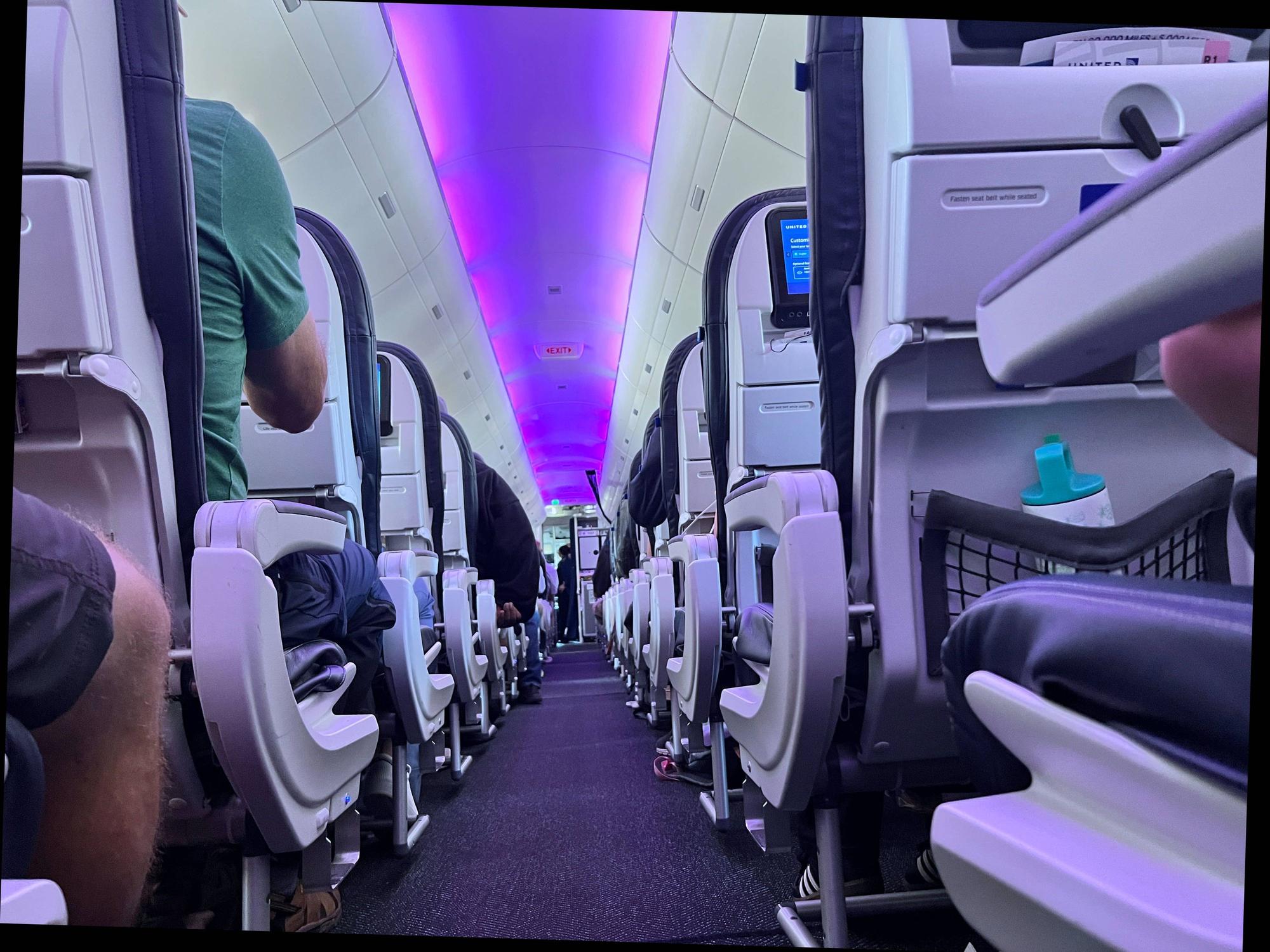 Menschen sitzen im Innenraum einer Maschine der Fluggesellschaft United Airlines.