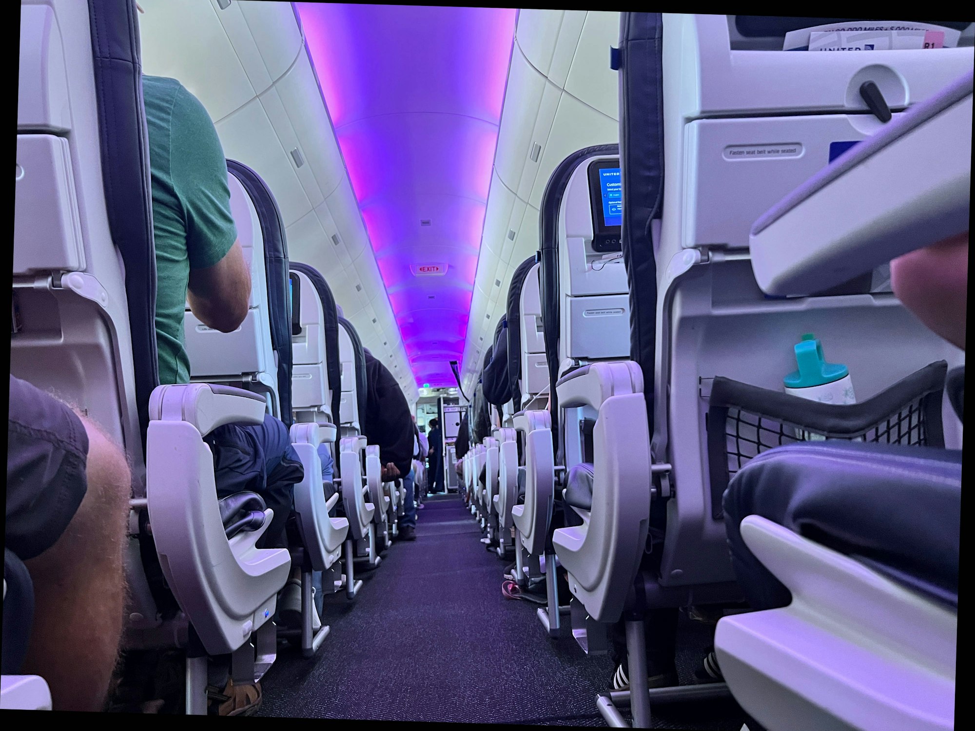 Menschen sitzen im Innenraum einer Maschine der Fluggesellschaft United Airlines.