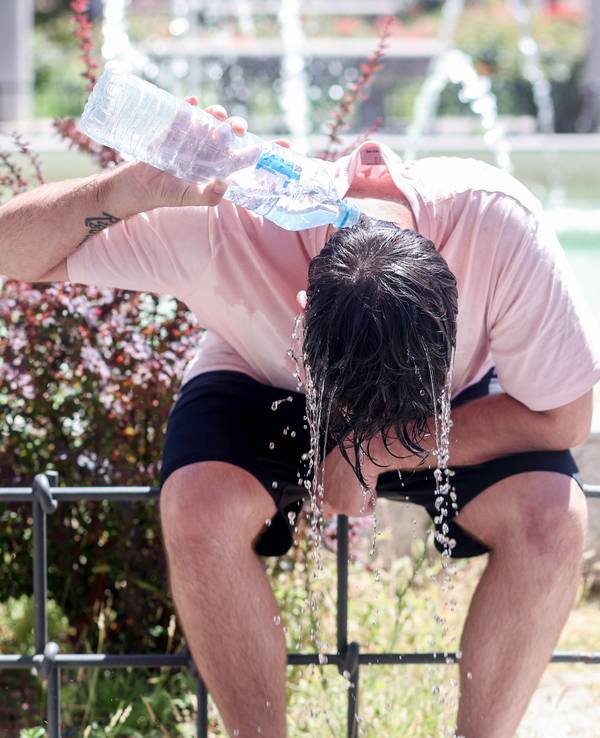 Ein Mann kühlt sich mit Wasser ab, hier im August 2023 in Madrid.