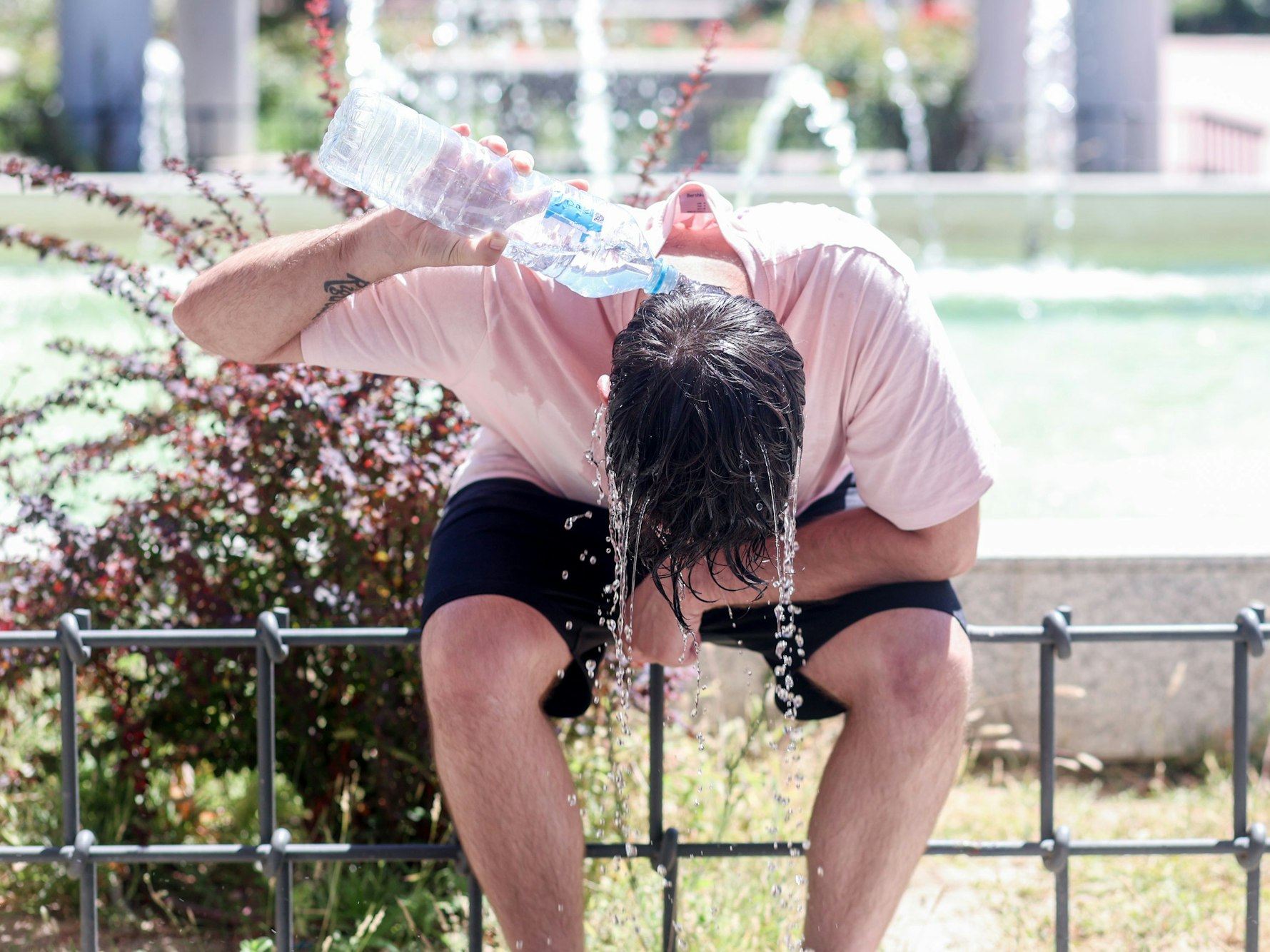 Ein Mann kühlt sich mit Wasser ab, hier im August 2023 in Madrid.