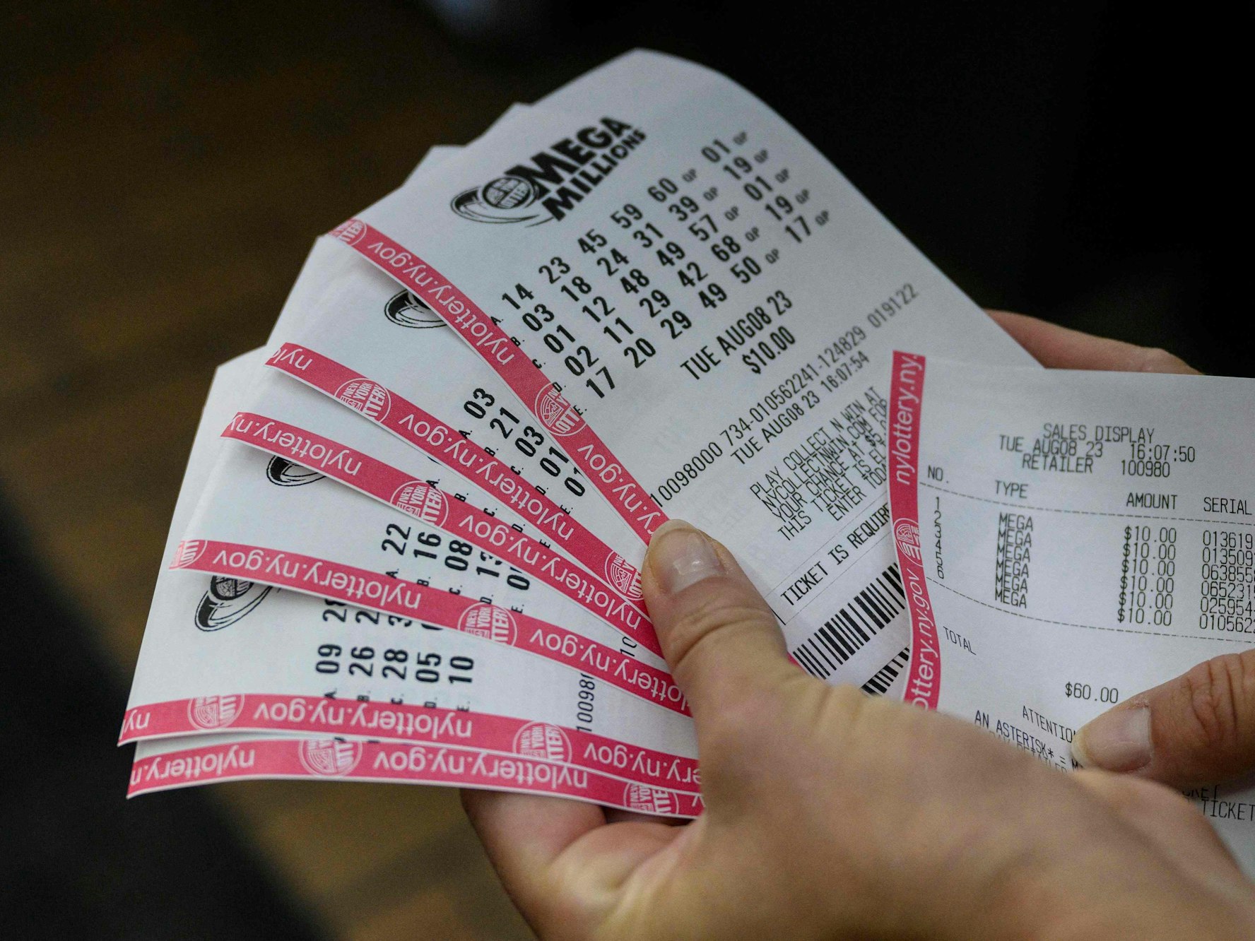 Eine Person hält ihre Mega-Millions-Spielscheine in der Hand.