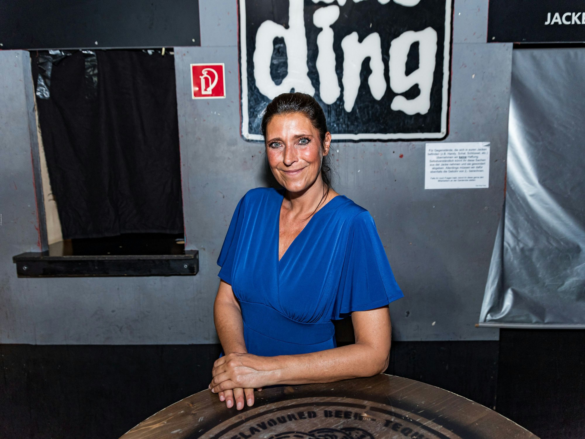 Claudia Wecker steht vorm Club Ding an einen Tisch gelehnt.