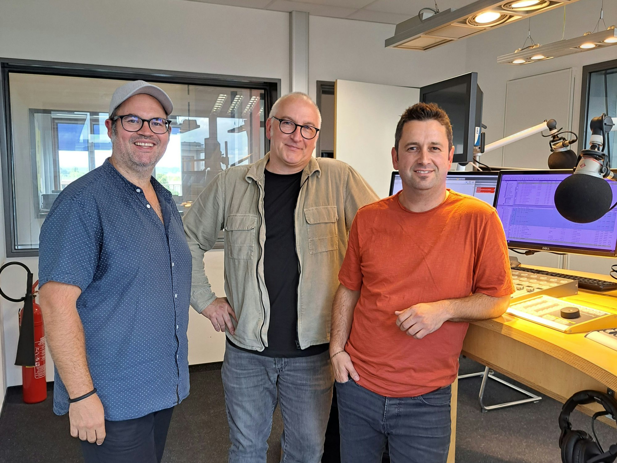 Björn Heuser, Georg Hinz und Dominik Becker lächeln in die Kamera.