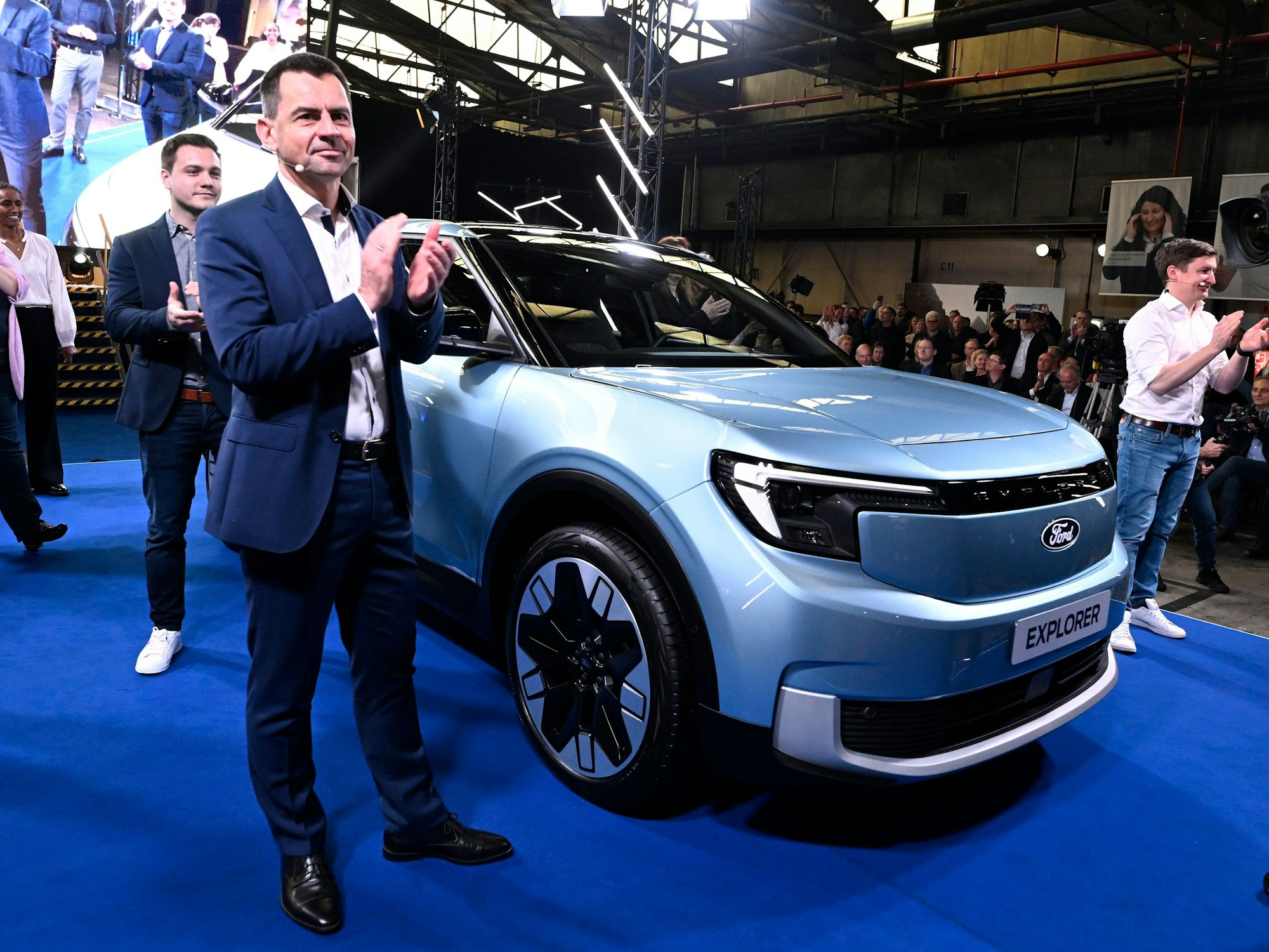 Martin Sander, Vorsitzender der Geschäftsführung der Ford-Werke GmbH, steht neben dem vollelektrischen Ford-Explorer.