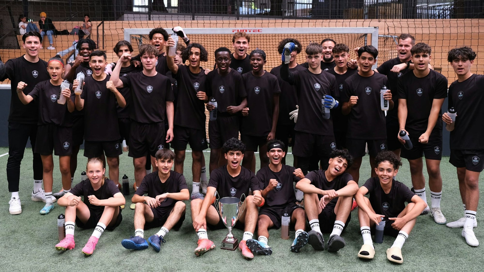 Die Spielerinnen und Spieler posieren auf dem Feld.