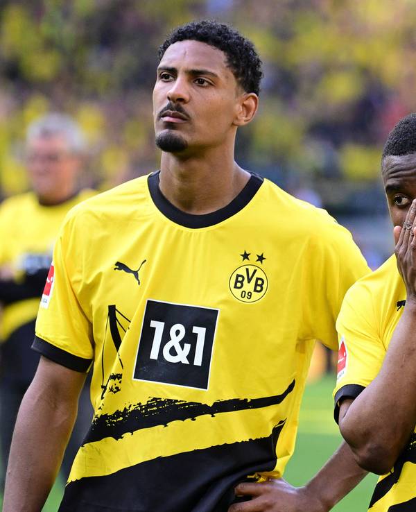 Dortmunds Haller steht neben Moukoko. Moukoko hat die Hände vor dem Gesicht gefaltet.