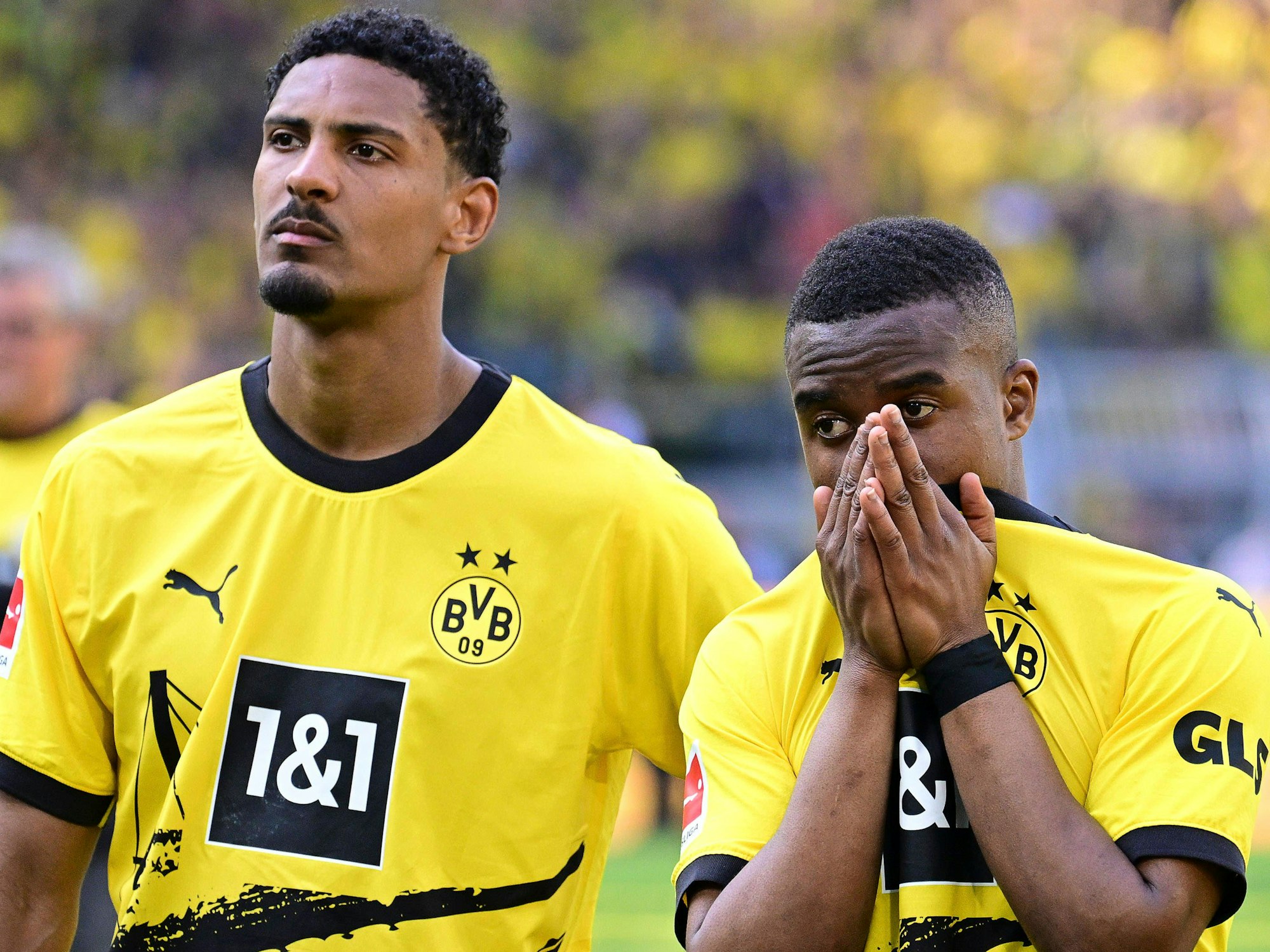 Dortmunds Haller steht neben Moukoko. Moukoko hat die Hände vor dem Gesicht gefaltet.