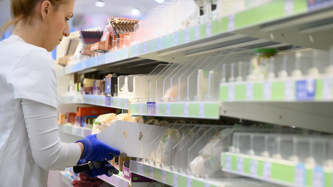 Eine Mitarbeiterin räumt in einem Drogeriemarkt der Kette dm-drogerie markt Nüsse in ein Regal.