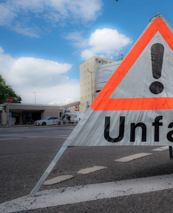 Ein mobiles Unfallschild steht auf einer Fahrbahn.