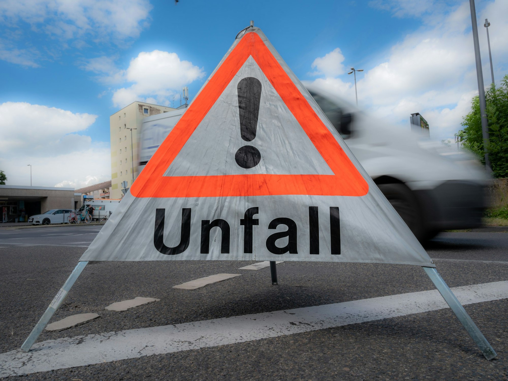 Ein mobiles Unfallschild steht auf einer Fahrbahn.