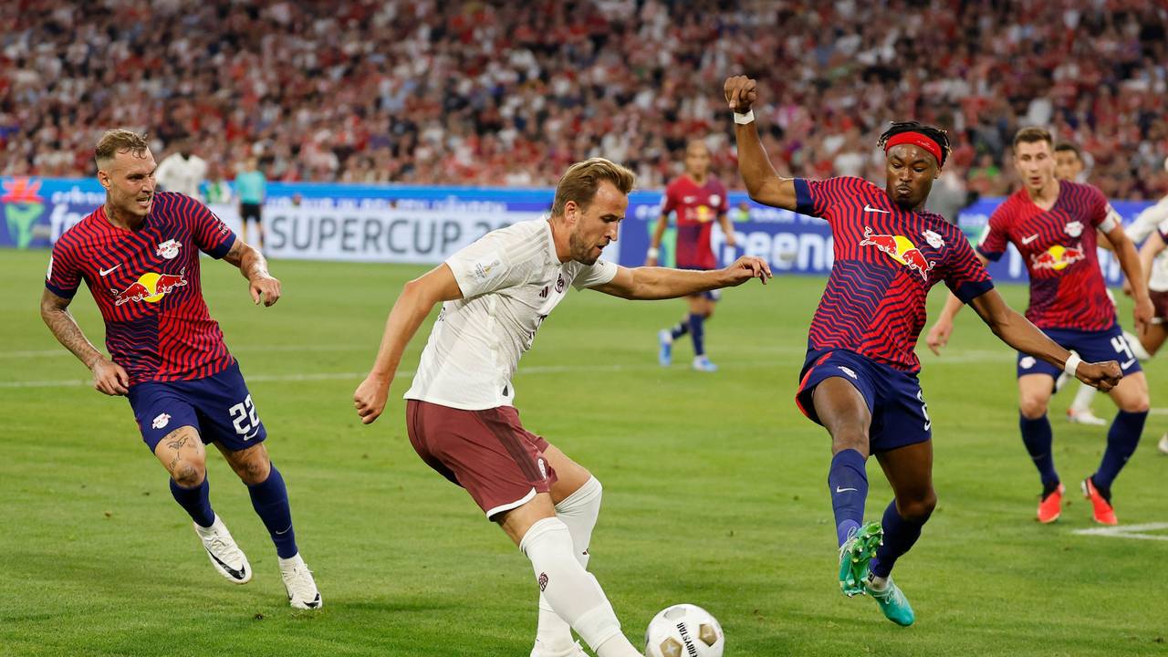 Bayerns Harry Kane (M) versucht sich gegen Leipzigs David Raum (l) und Leipzigs Mohamed Simakan durchzusetzen.