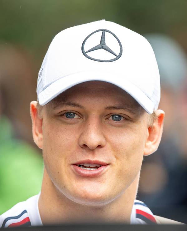 Mick Schumacher lächelt. Er trägt eine Mercedes-Kappe.