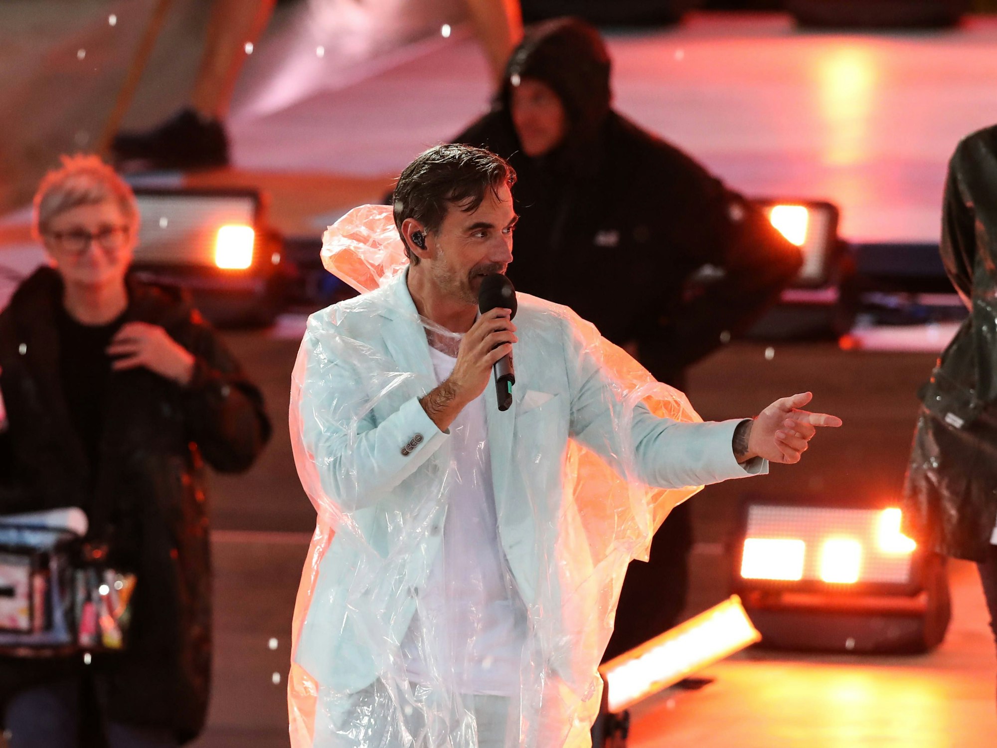 Moderator Florian Silbereisen mit Regenponcho muss die Aufzeichnung wegen Unwetter unterbrechen.