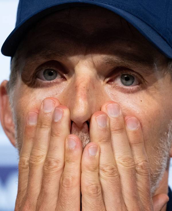 Bayern-Trainer Thomas Tuchel schlägt auf einer Pressekonferenz geschockt die Hände vors Gesicht.