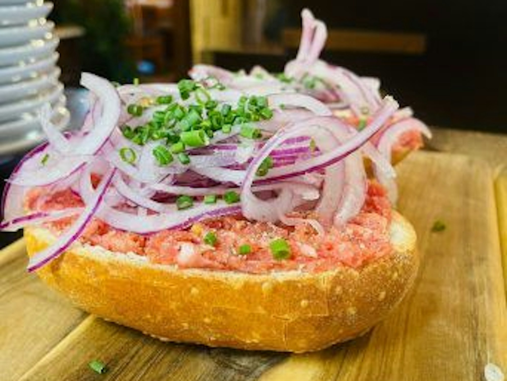 Ein halbes Brötchen belegt mit Mett und Zwiebeln