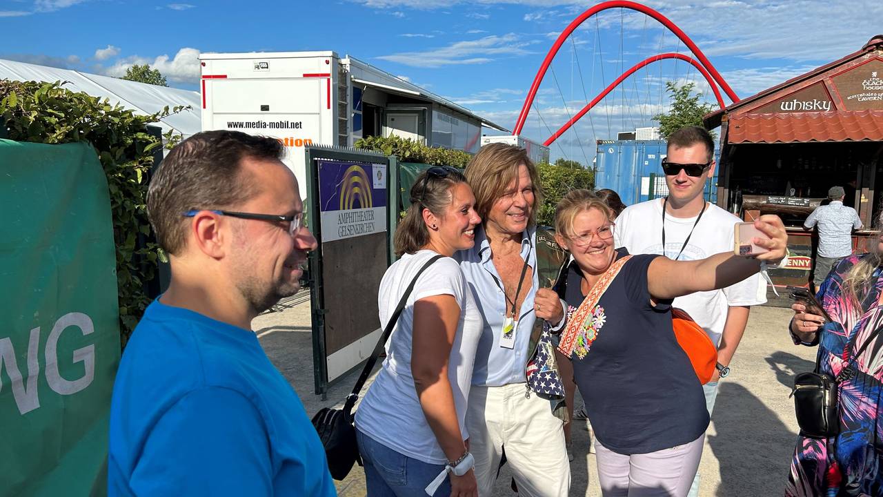 Jürgen Drews posiert mit Fans für Selfies.