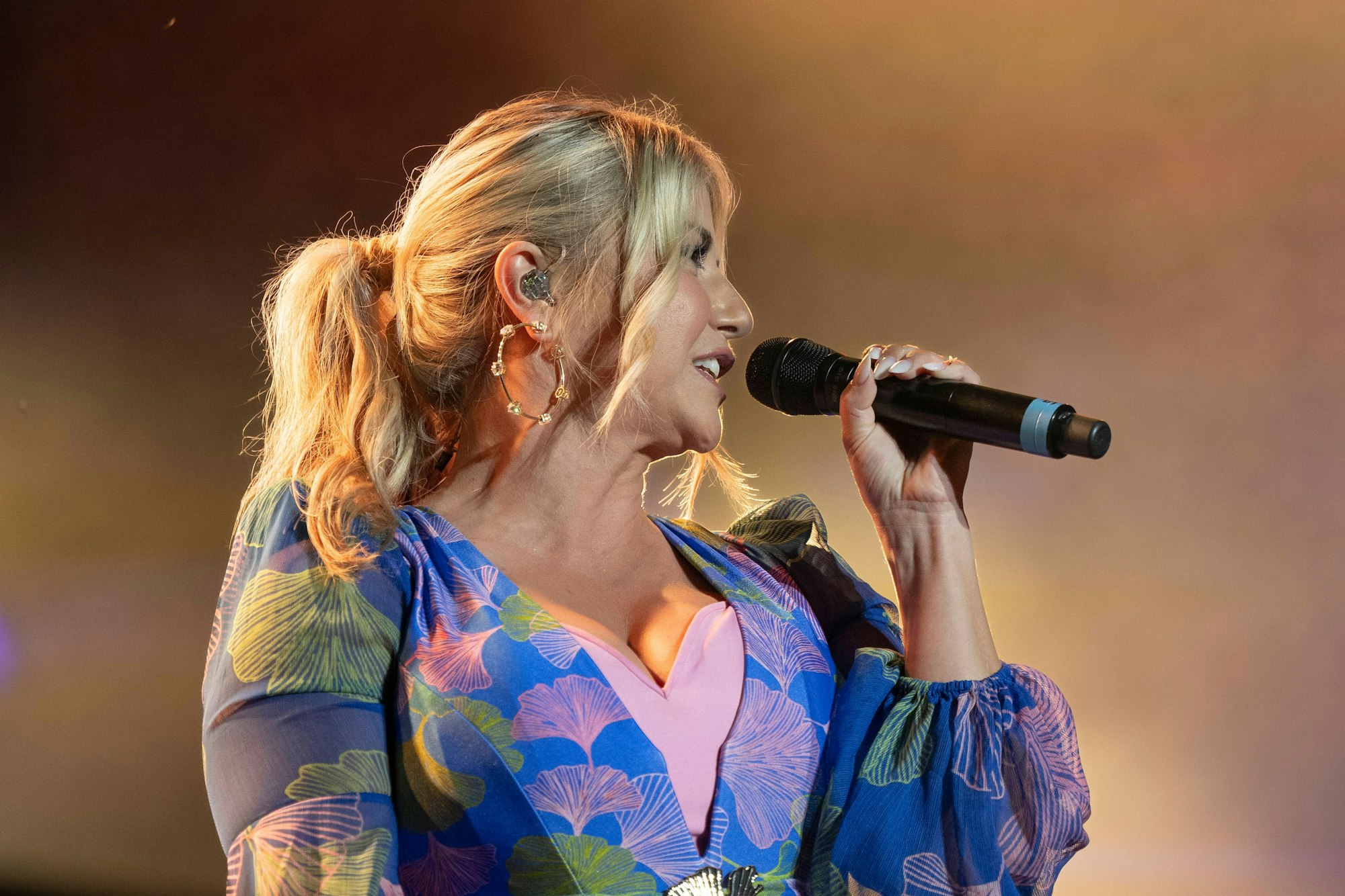 Beatrice Egli hält ein Mikrofon in der Hand.