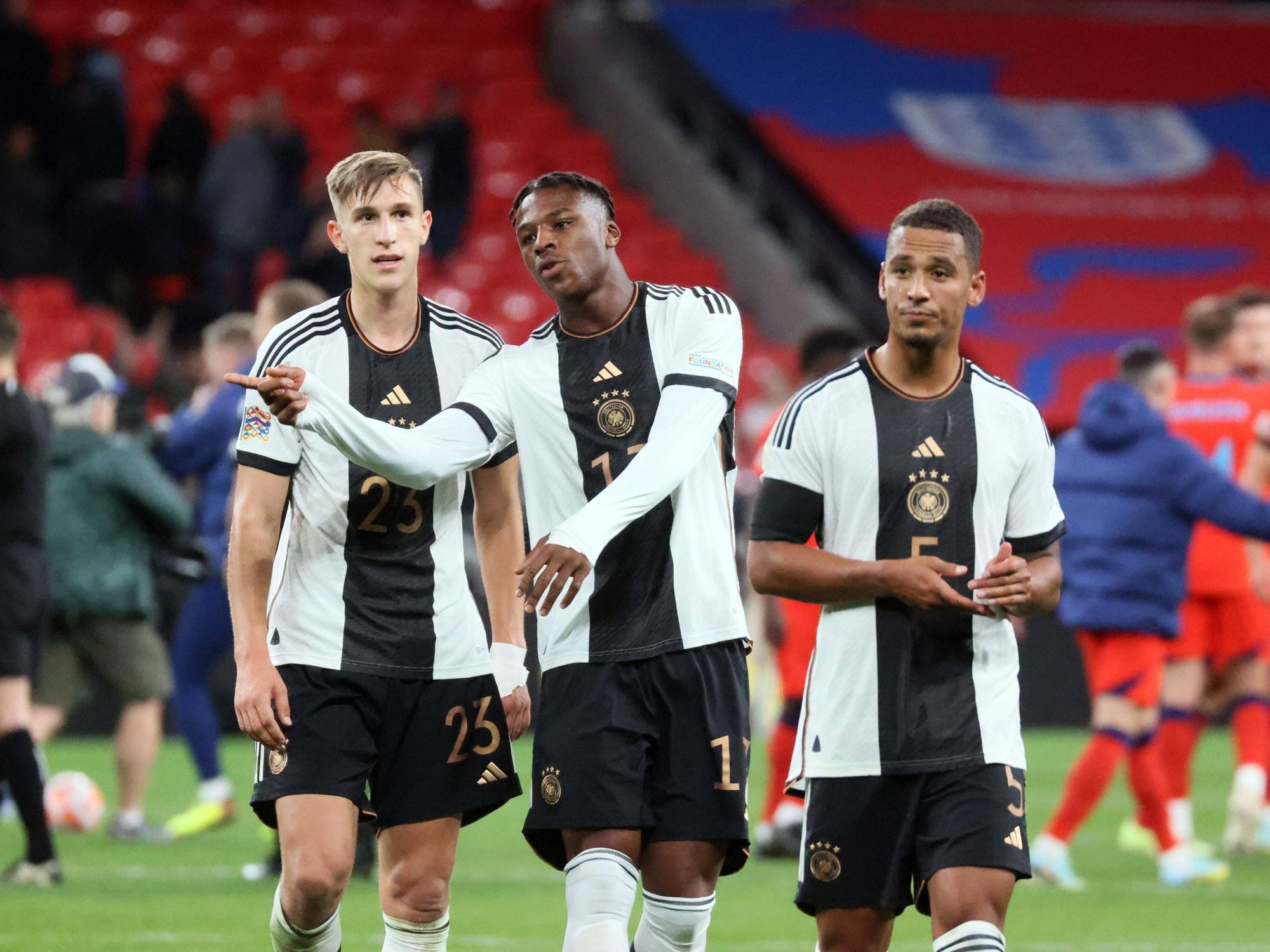 Die DFB-Stars Nico Schlotterbeck (l.) und Armel Bella Kotchap (M.) besprechen sich nach dem Spiel gegen England.