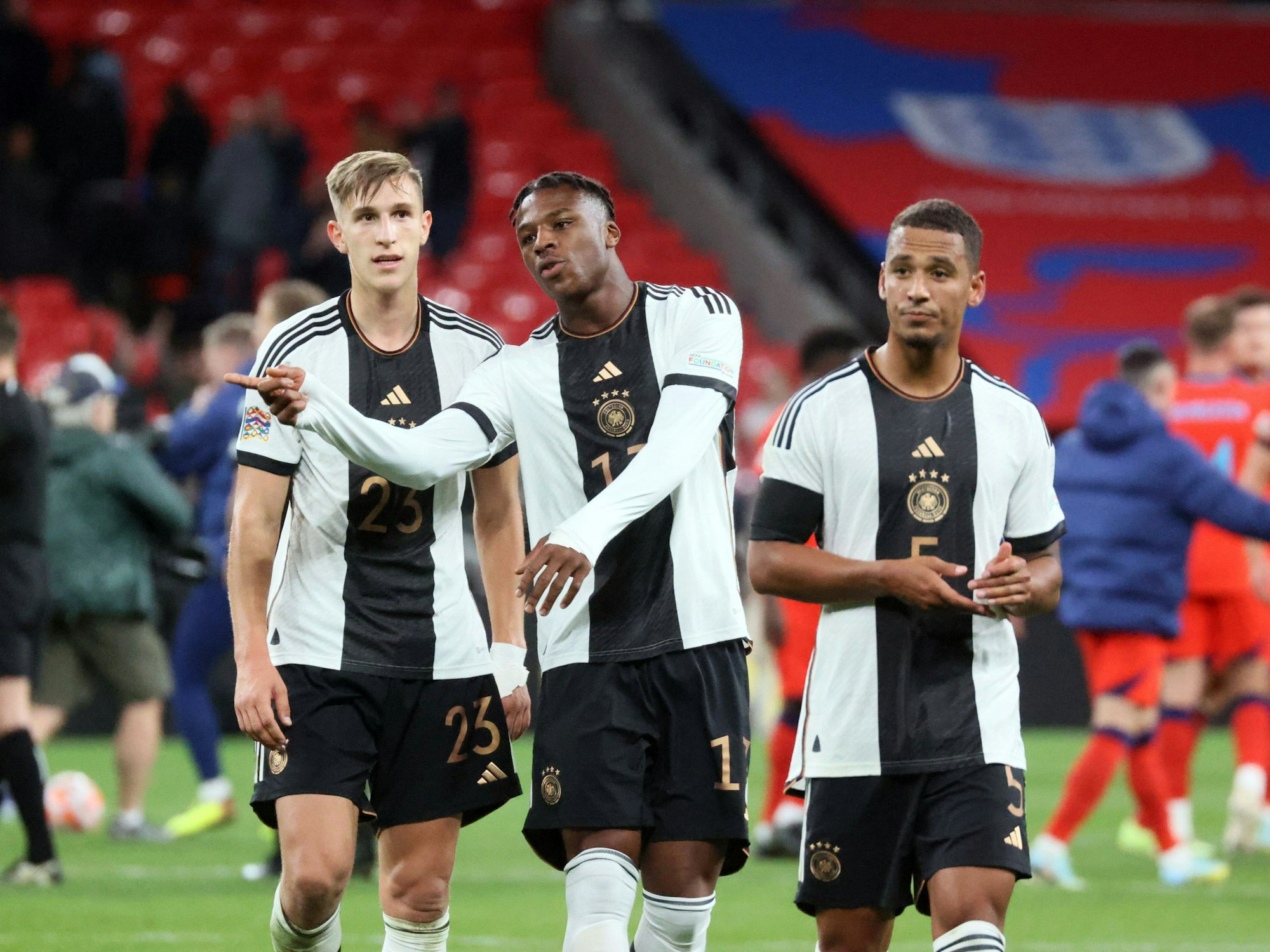 Die DFB-Stars Nico Schlotterbeck (l.) und Armel Bella Kotchap (M.) besprechen sich nach dem Spiel gegen England.
