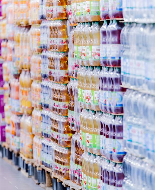 Plastikflaschen stehen in einem Supermarkt auf Paletten.